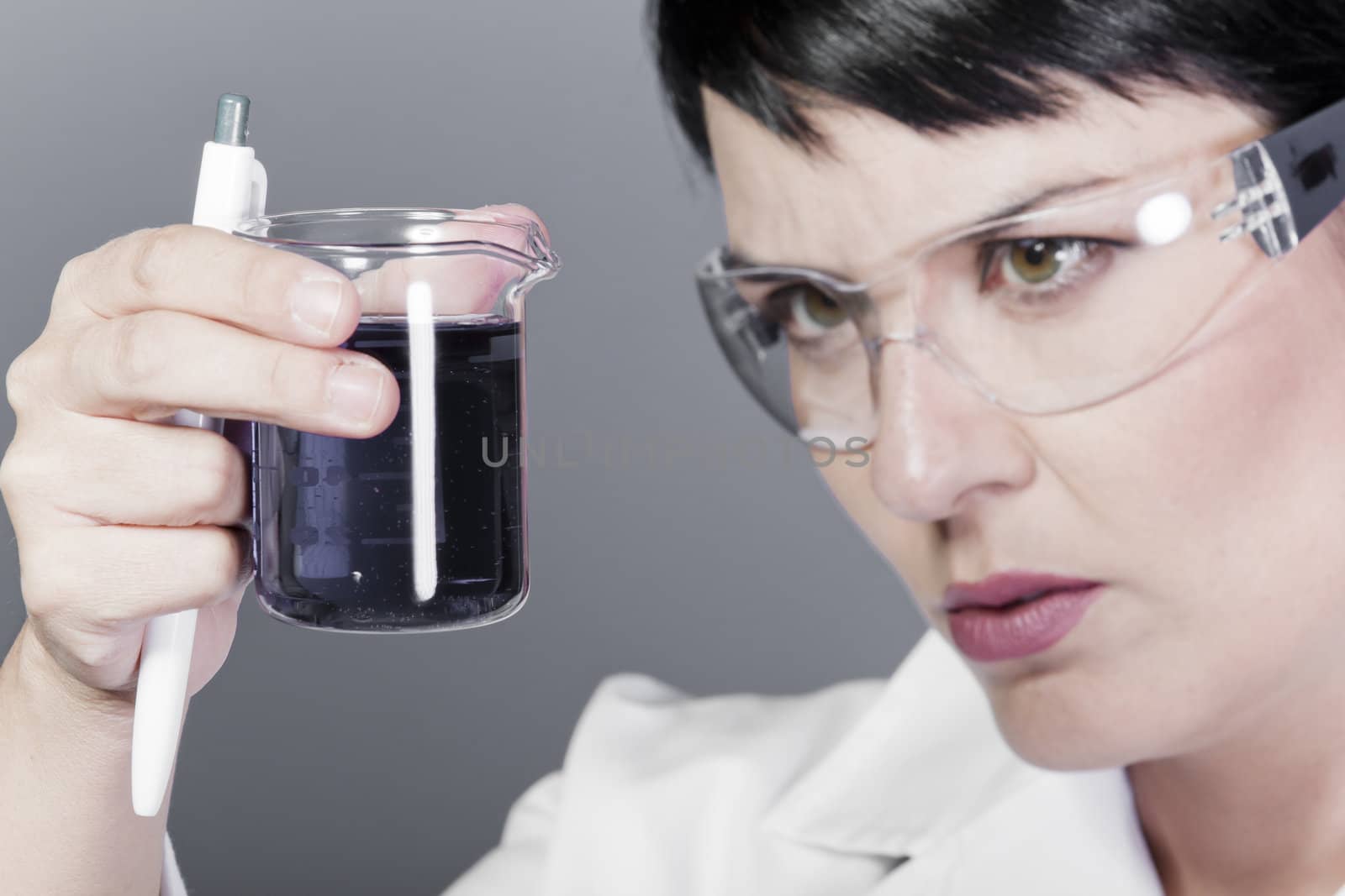 A medical or scientific researcher or doctor looking at a liquid clear solution in a laboratory.