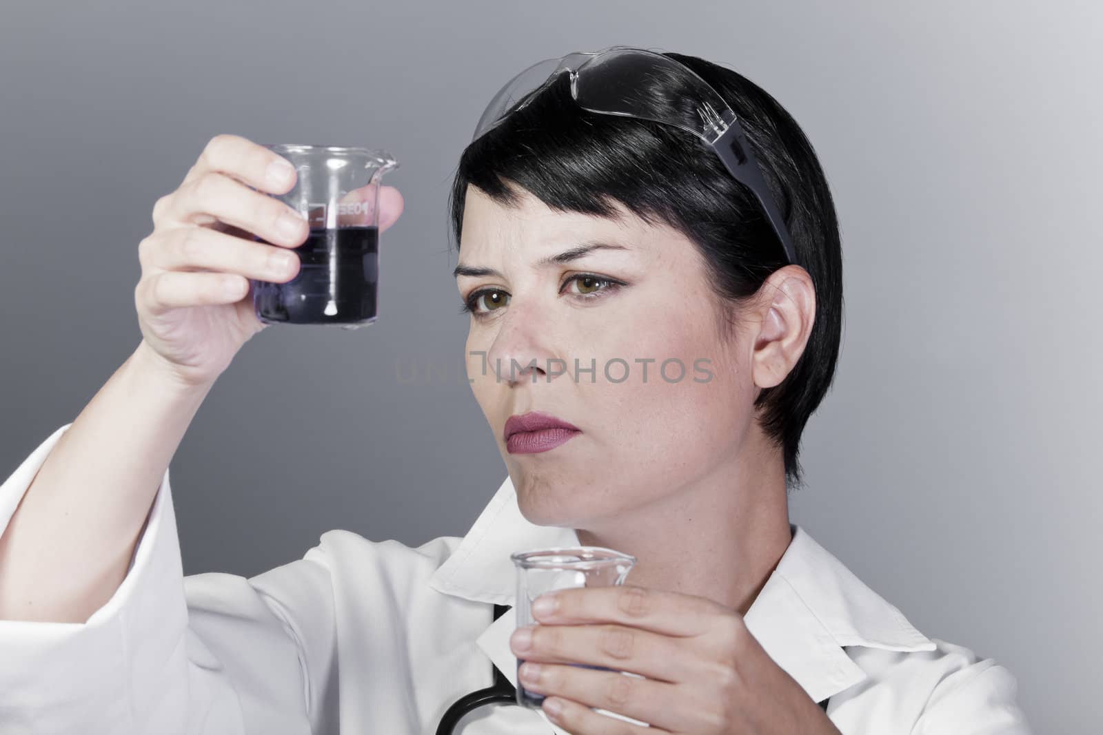 Scientific researcher or doctor looking at a liquid clear solution in a laboratory.