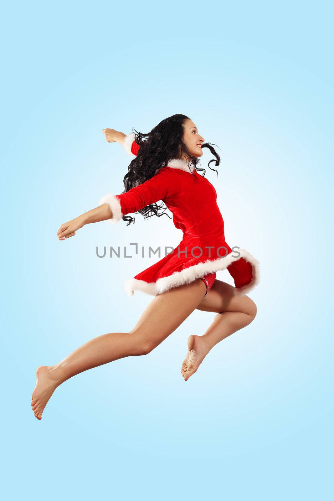 Happy smiling woman in red xmas costume jumping high