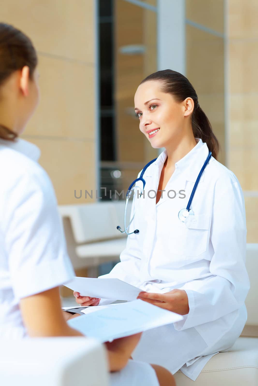 Portrait of two friendly female doctors in hospital discussing something