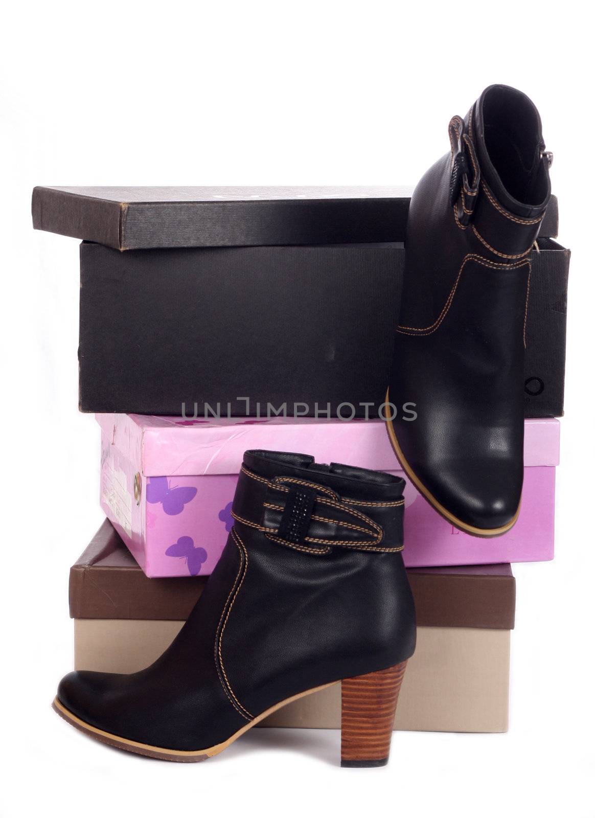 Pair of black winter woman boots and many boxes over white
