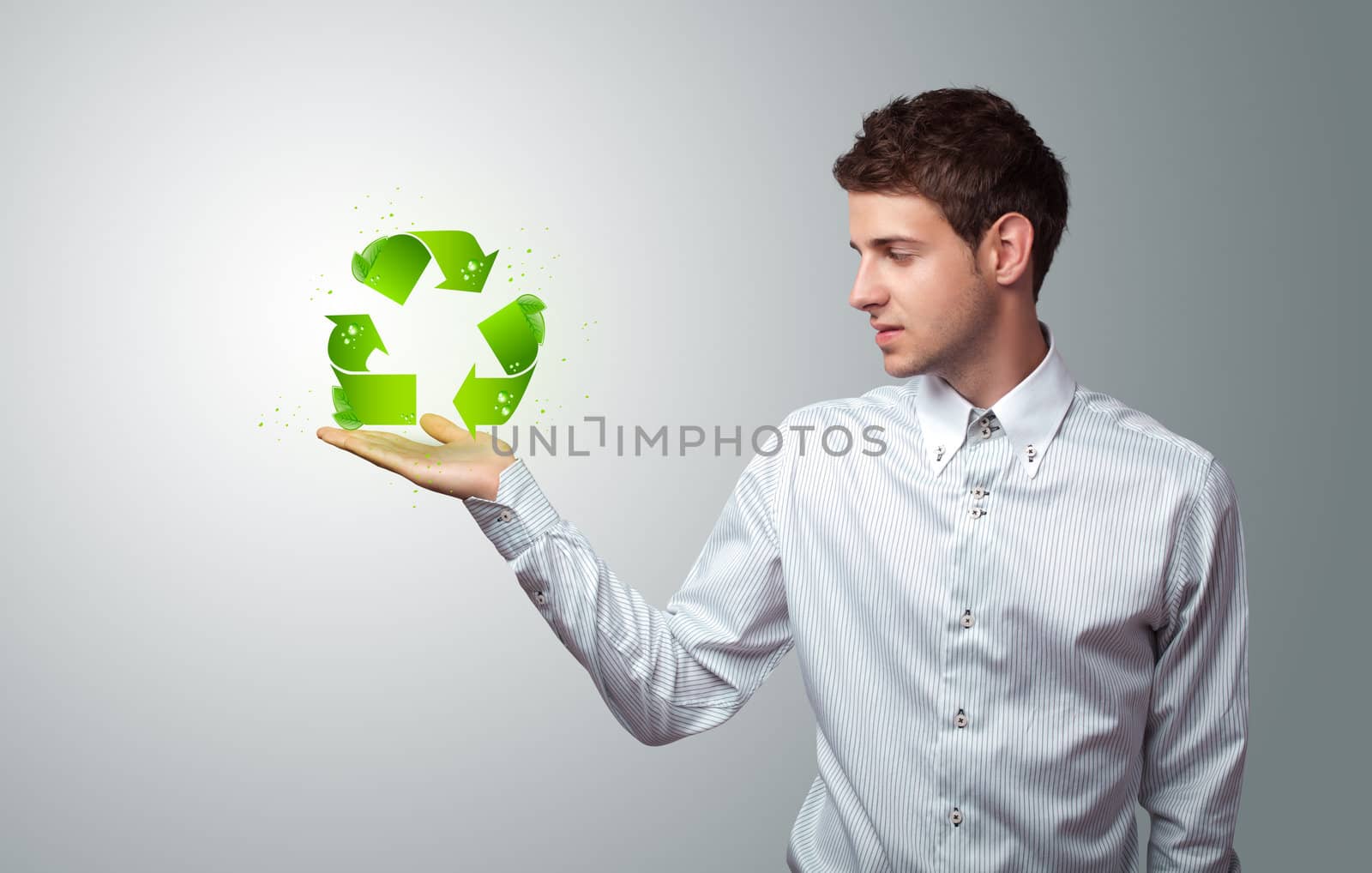 Young businessman holding virtual eco sign