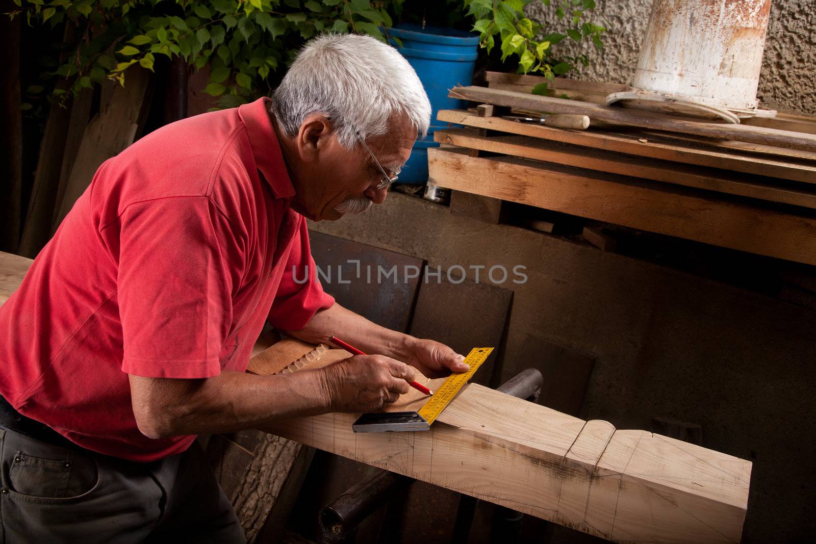 Old woodcarver working with mallet by ra2studio