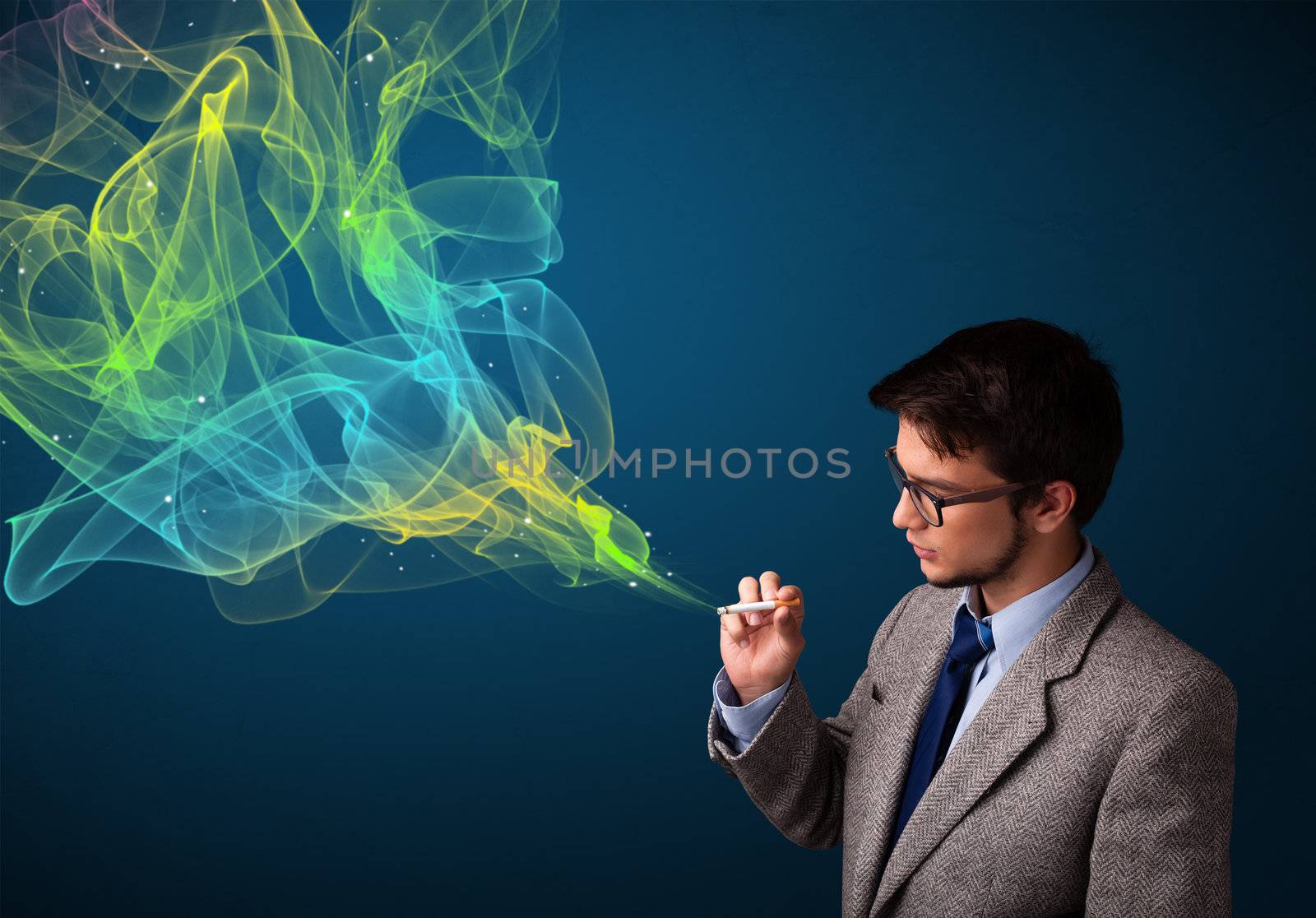 Handsome young man smoking cigarette with colorful smoke