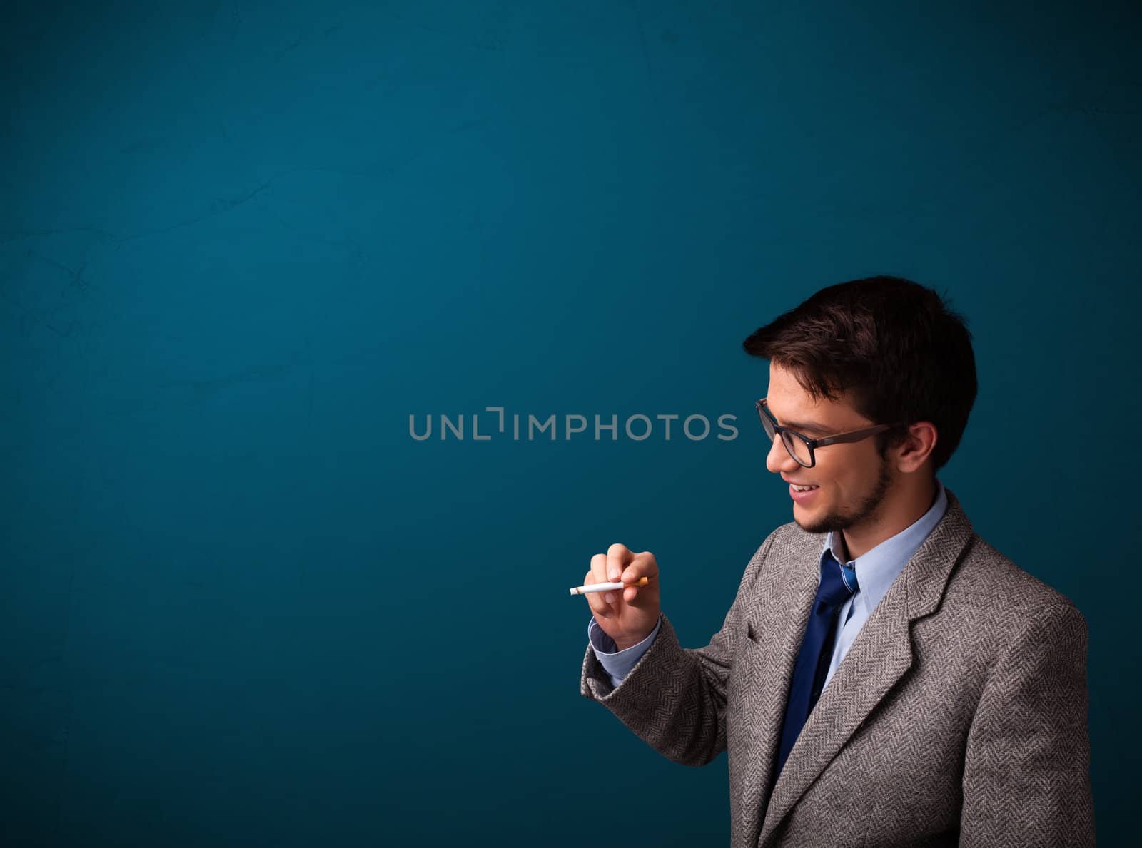 Handsome young man smoking cigarette with copy space