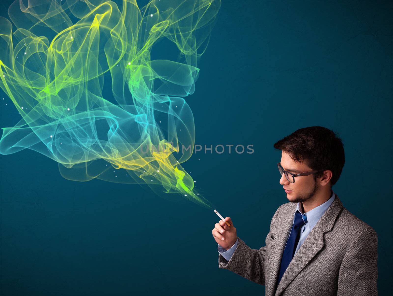 Handsome young man smoking cigarette with colorful smoke