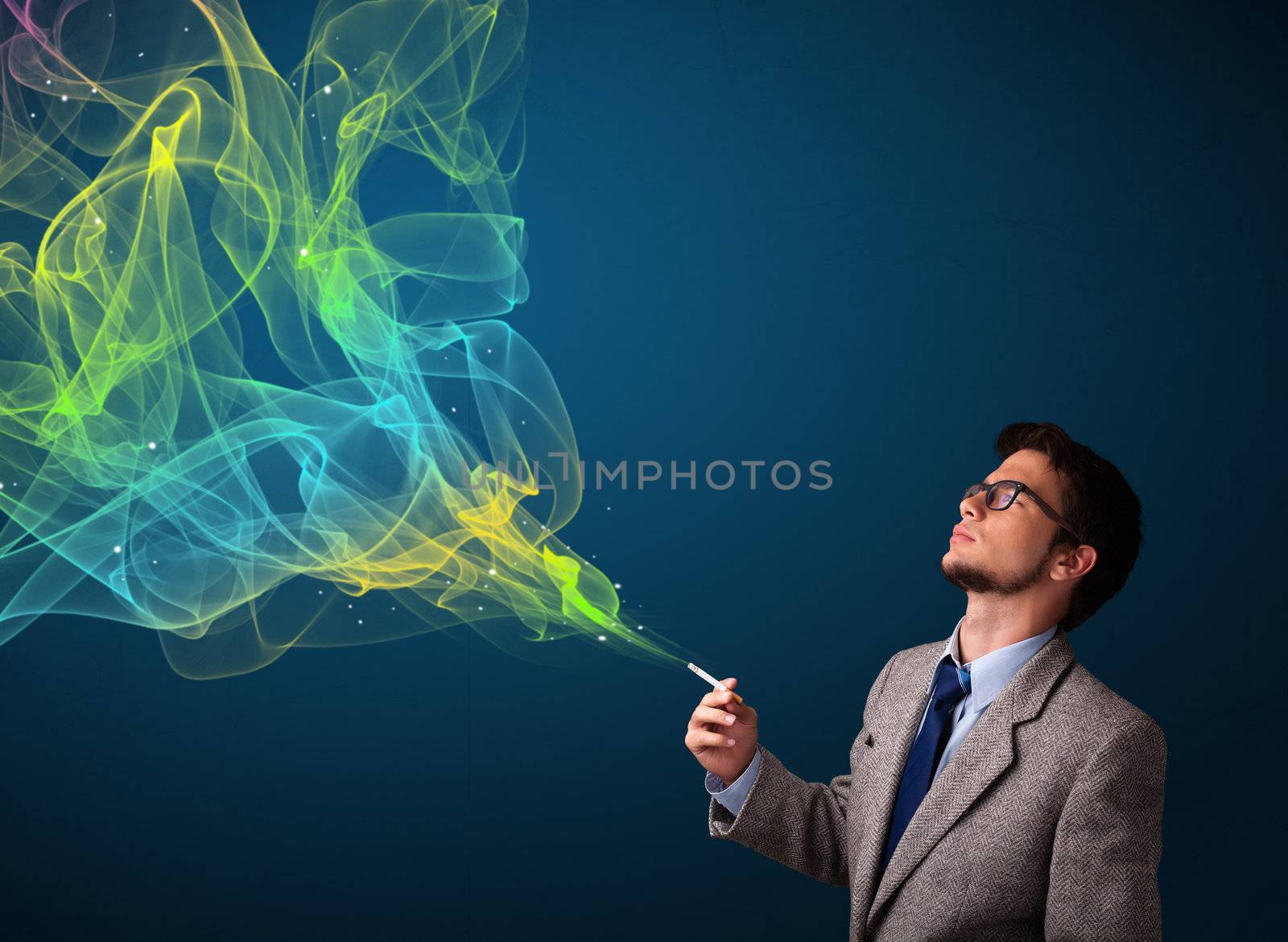 Handsome young man smoking cigarette with colorful smoke