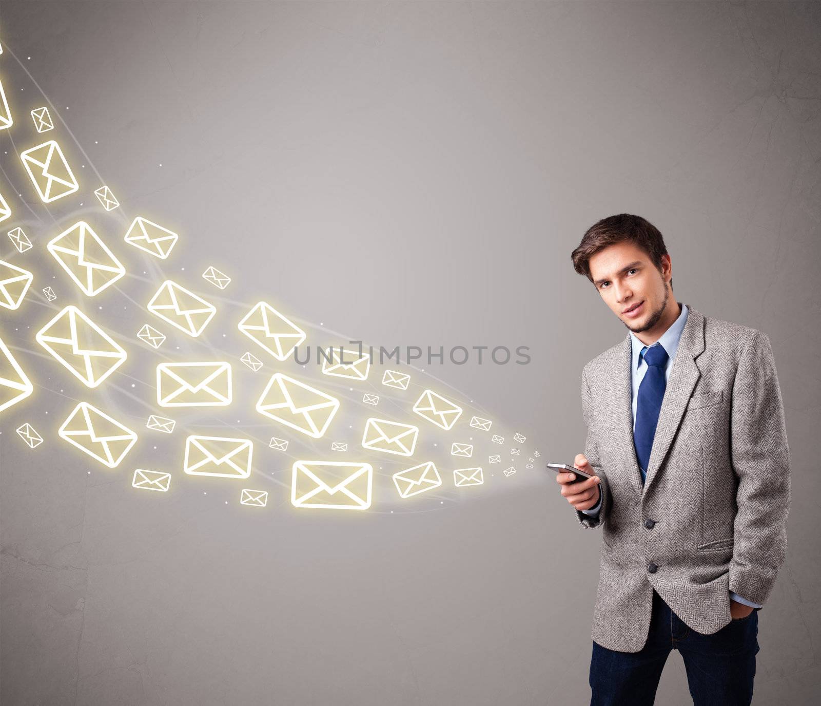 attractive young man standing and holding a phone with message icons