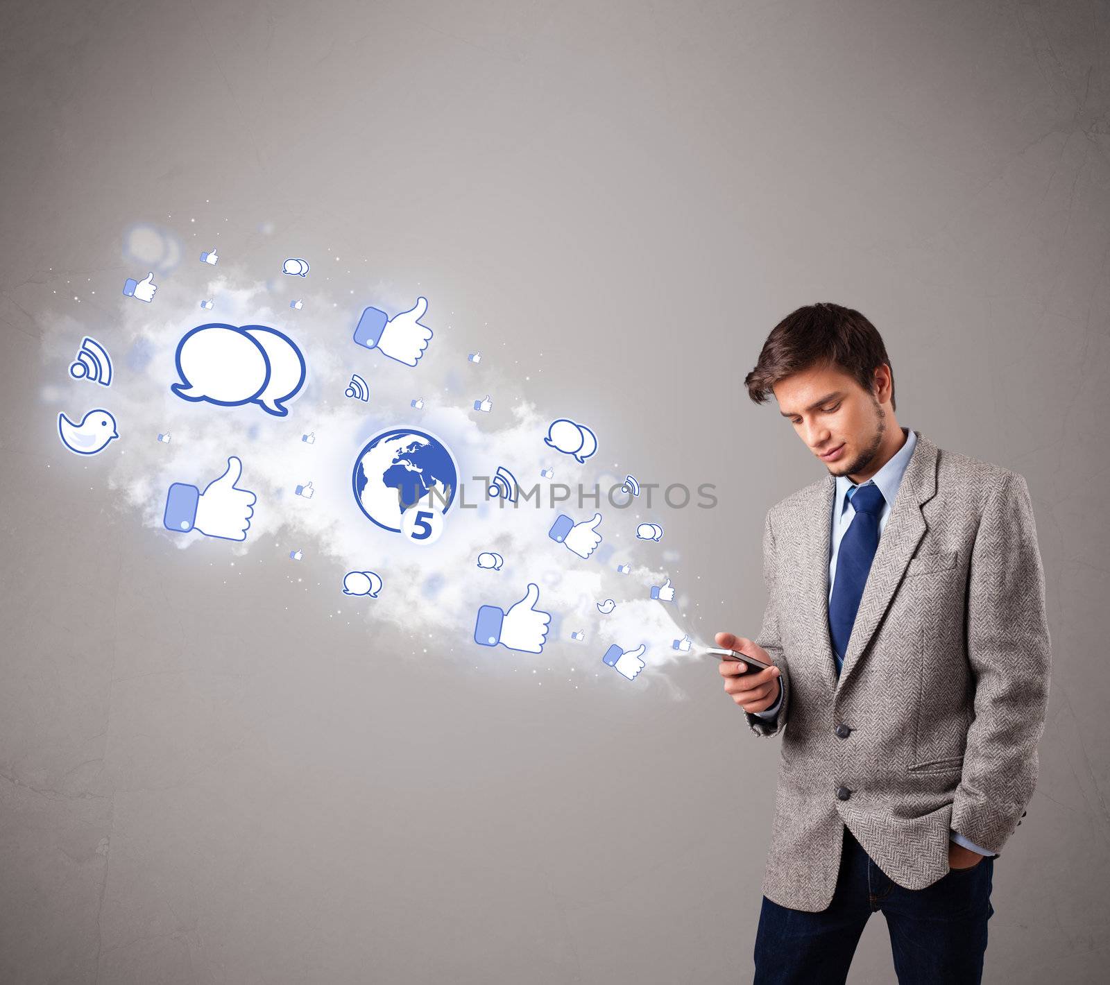 attractive young man holding a phone with social media icons by ra2studio