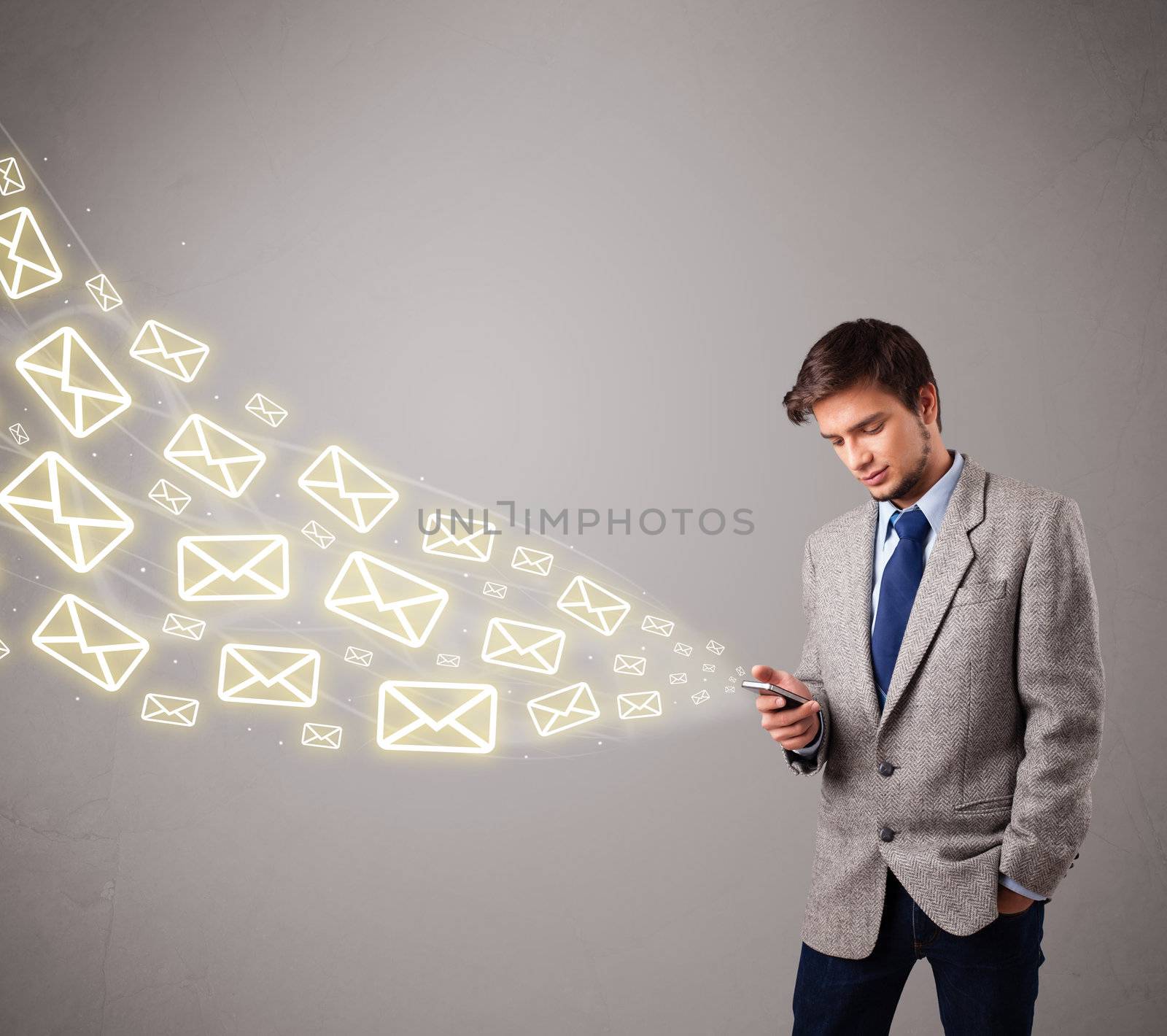 attractive young man standing and holding a phone with message icons