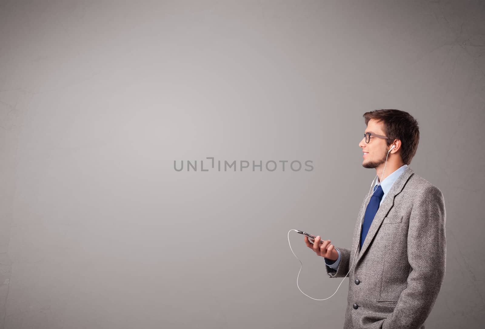 handsome young man singing and listening to music with copy space