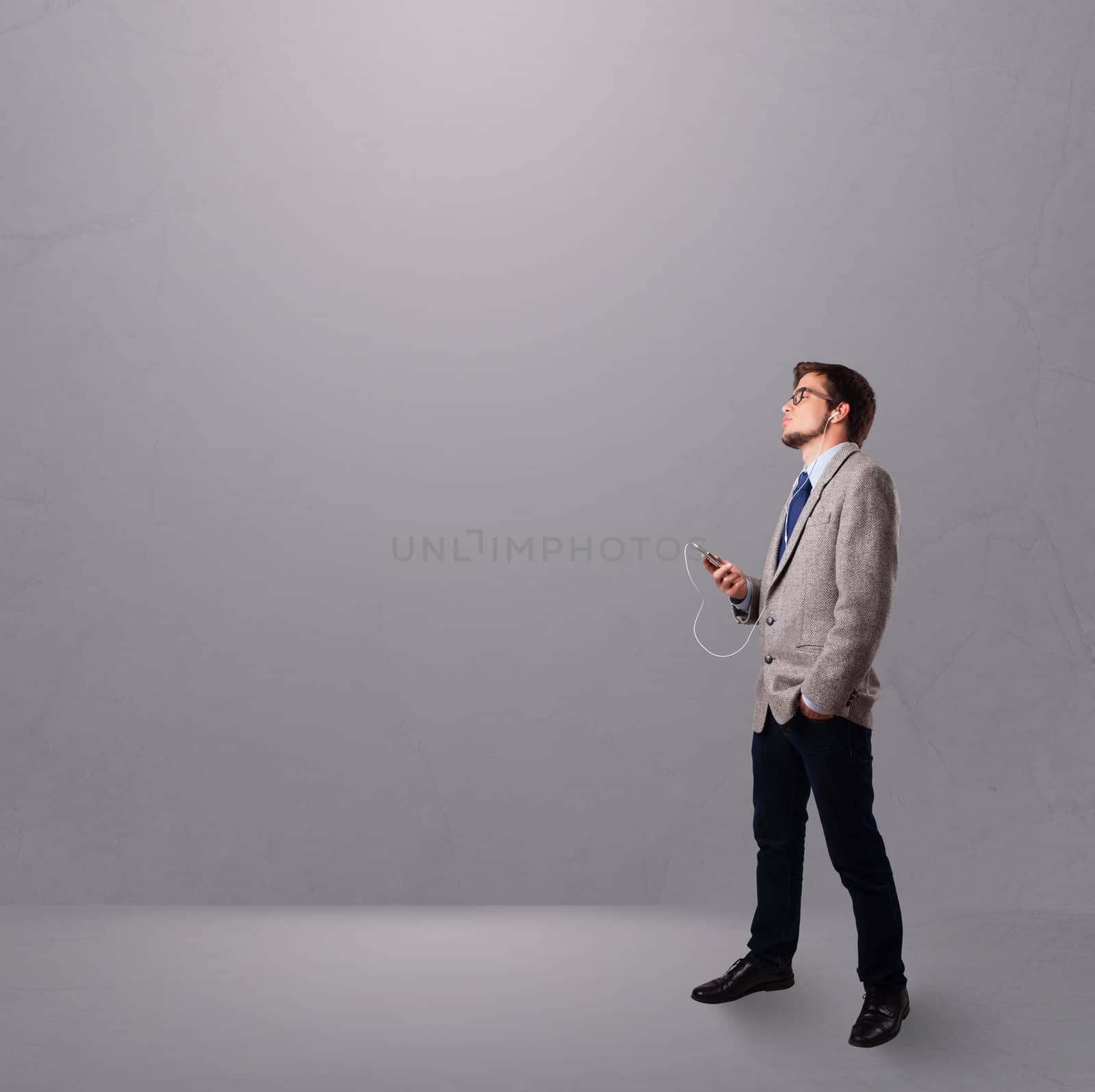 handsome young man singing and listening to music with copy space