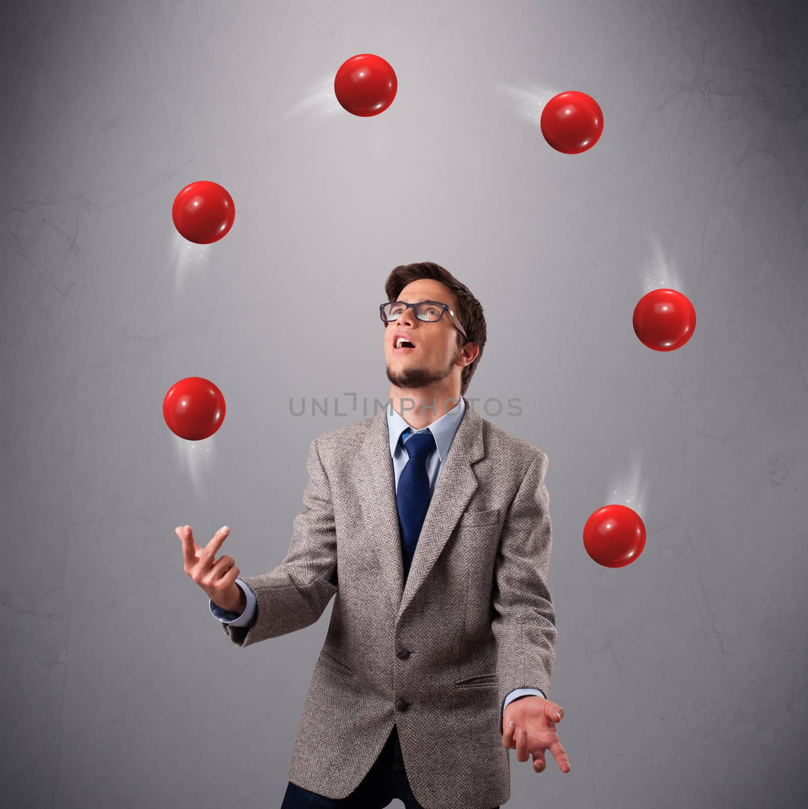 young man standing and juggling with red balls by ra2studio