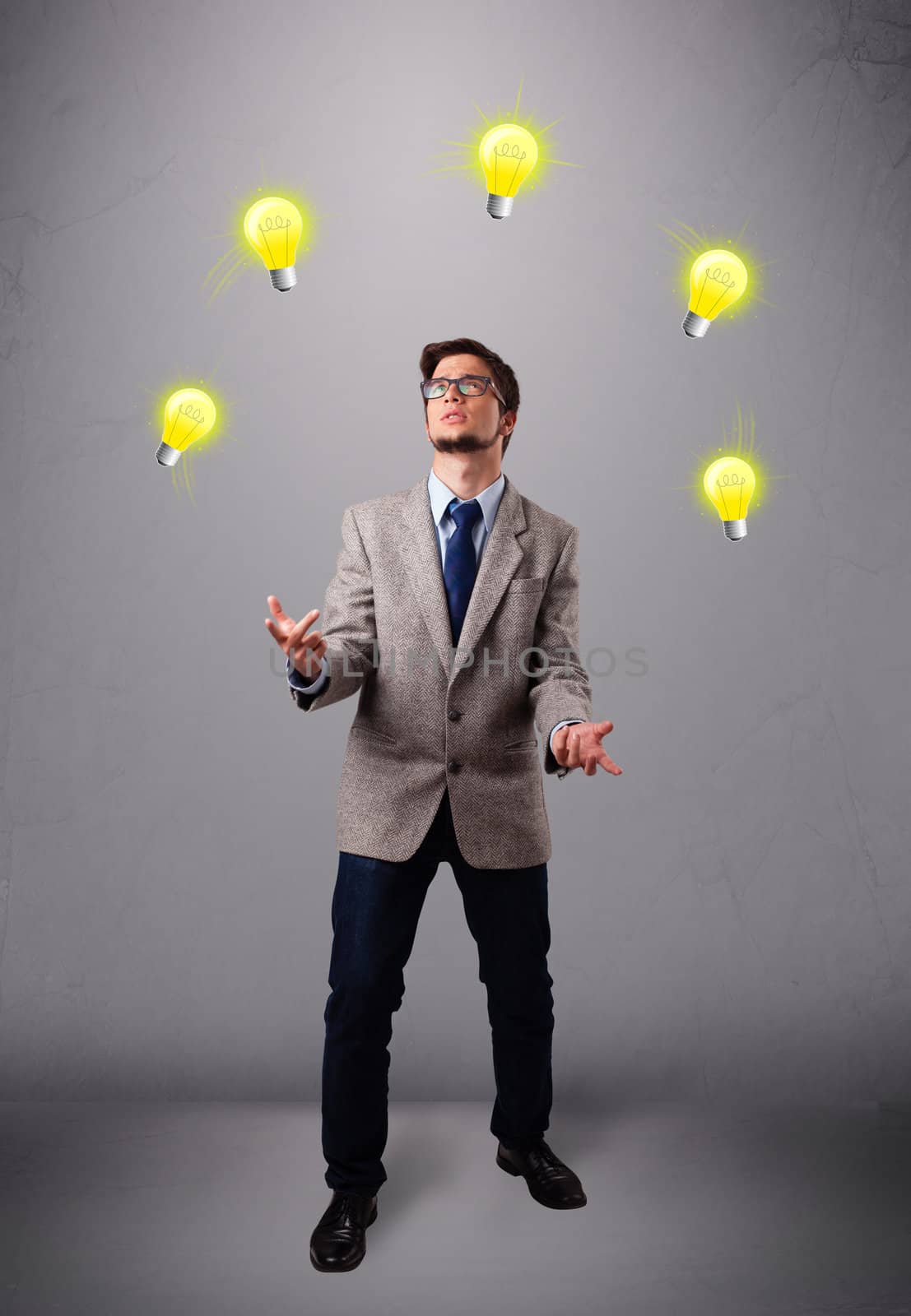 young man standing and juggling with light bulbs by ra2studio