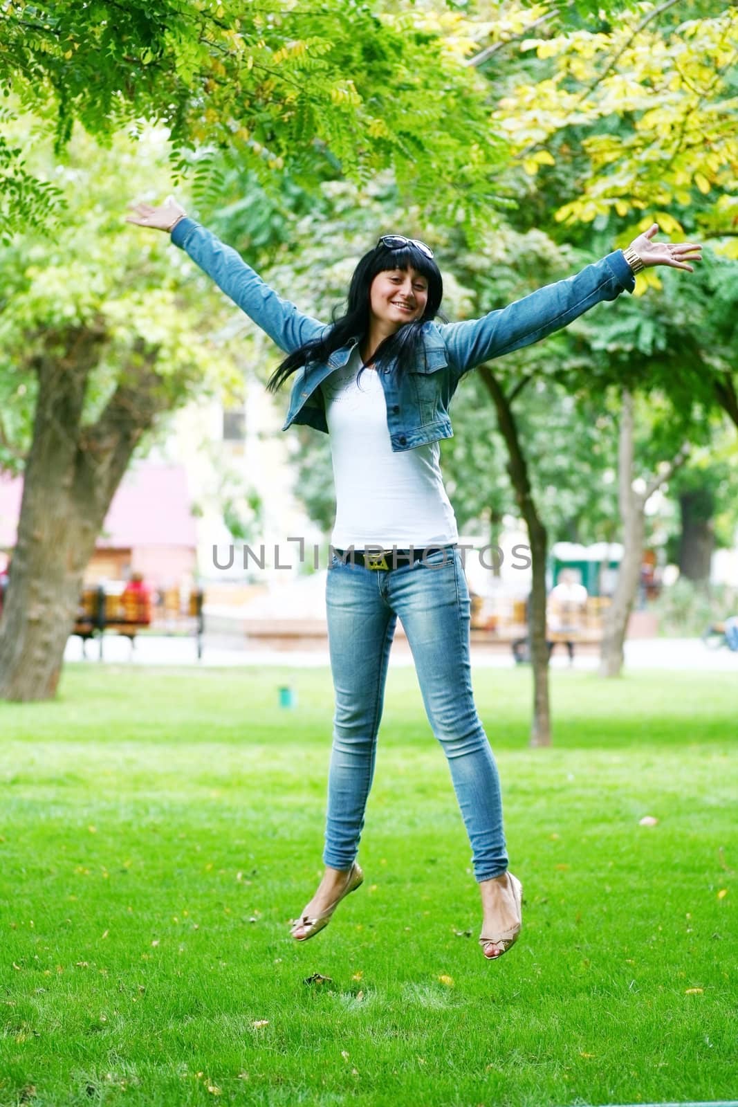 photo of young woman jamping on a grass