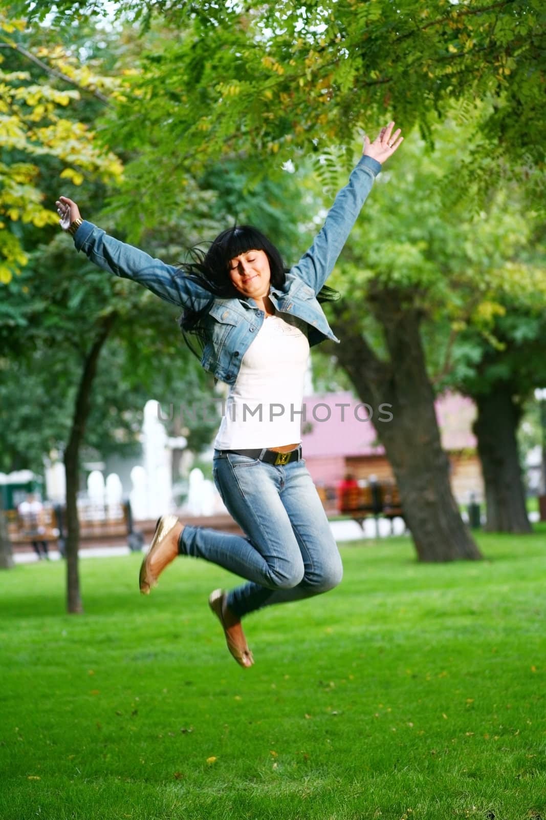 photo of young woman jamping on a grass