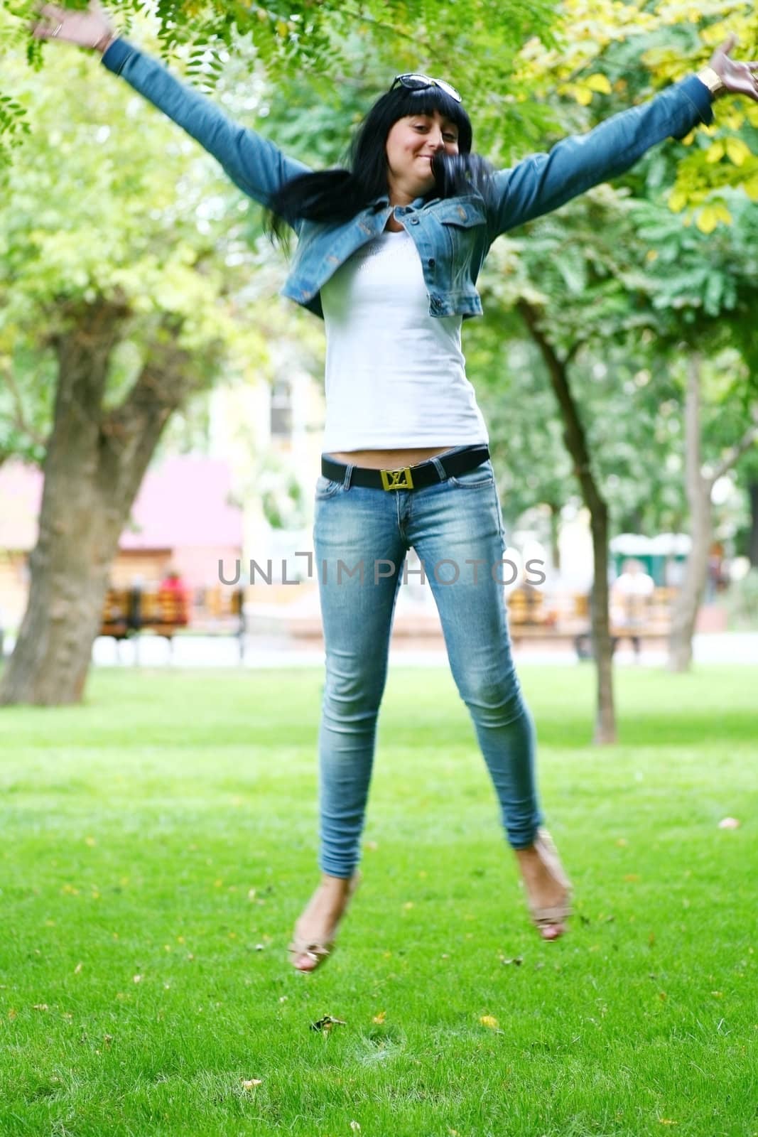 photo of young woman jamping on a grass