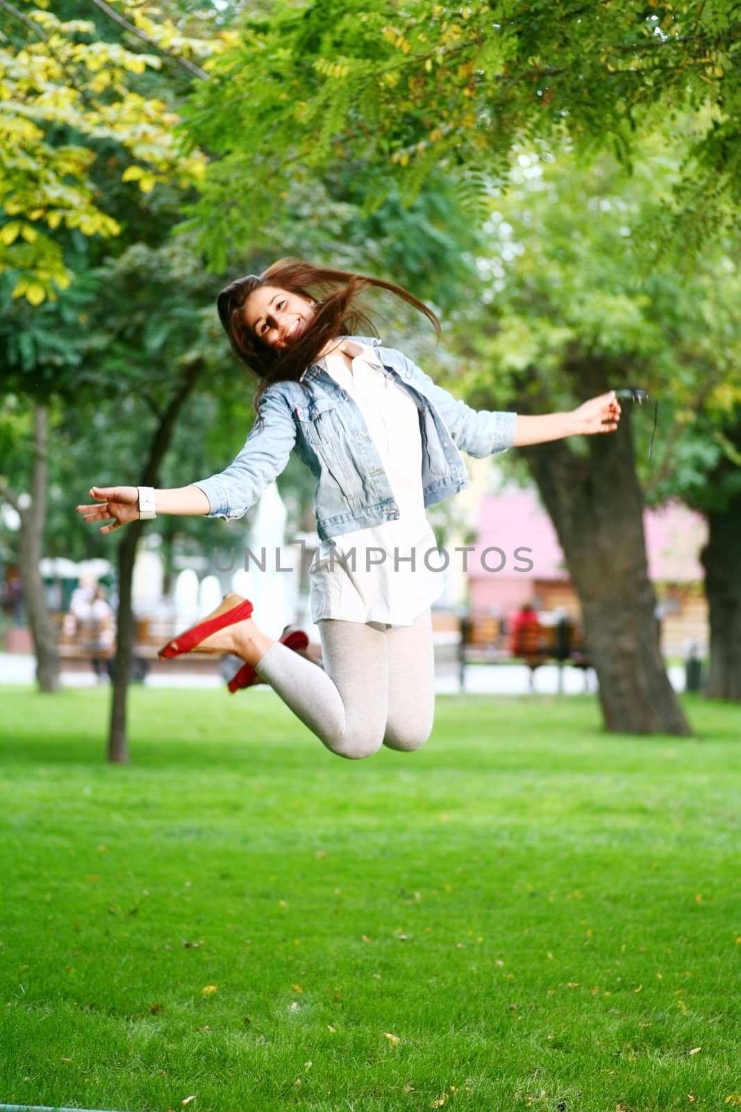 young woman jamping on a grass by mettus