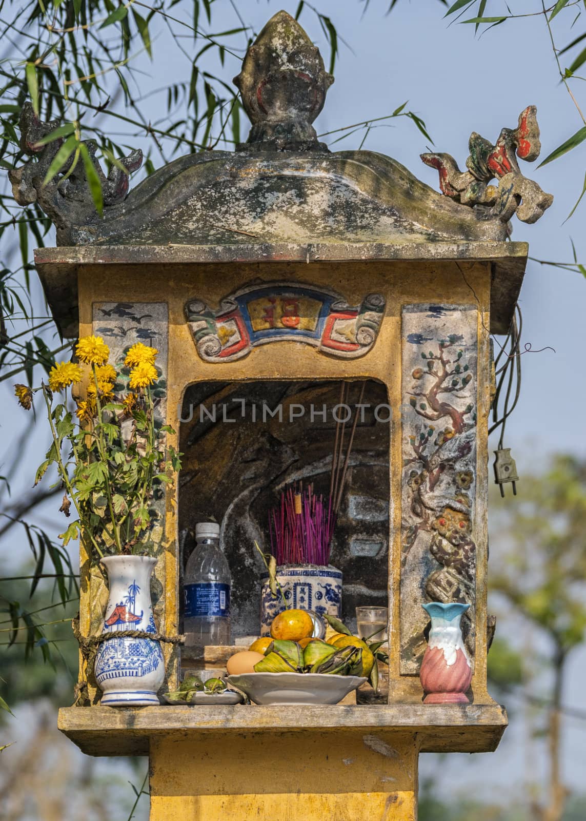 Vietnam: Small shrine along the road with cute painting, flowers by Claudine