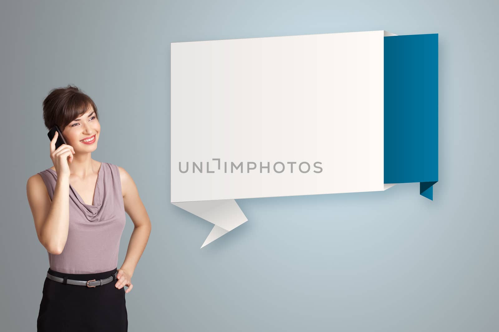 pretty young woman standing next to modern origami copy space and making phone call