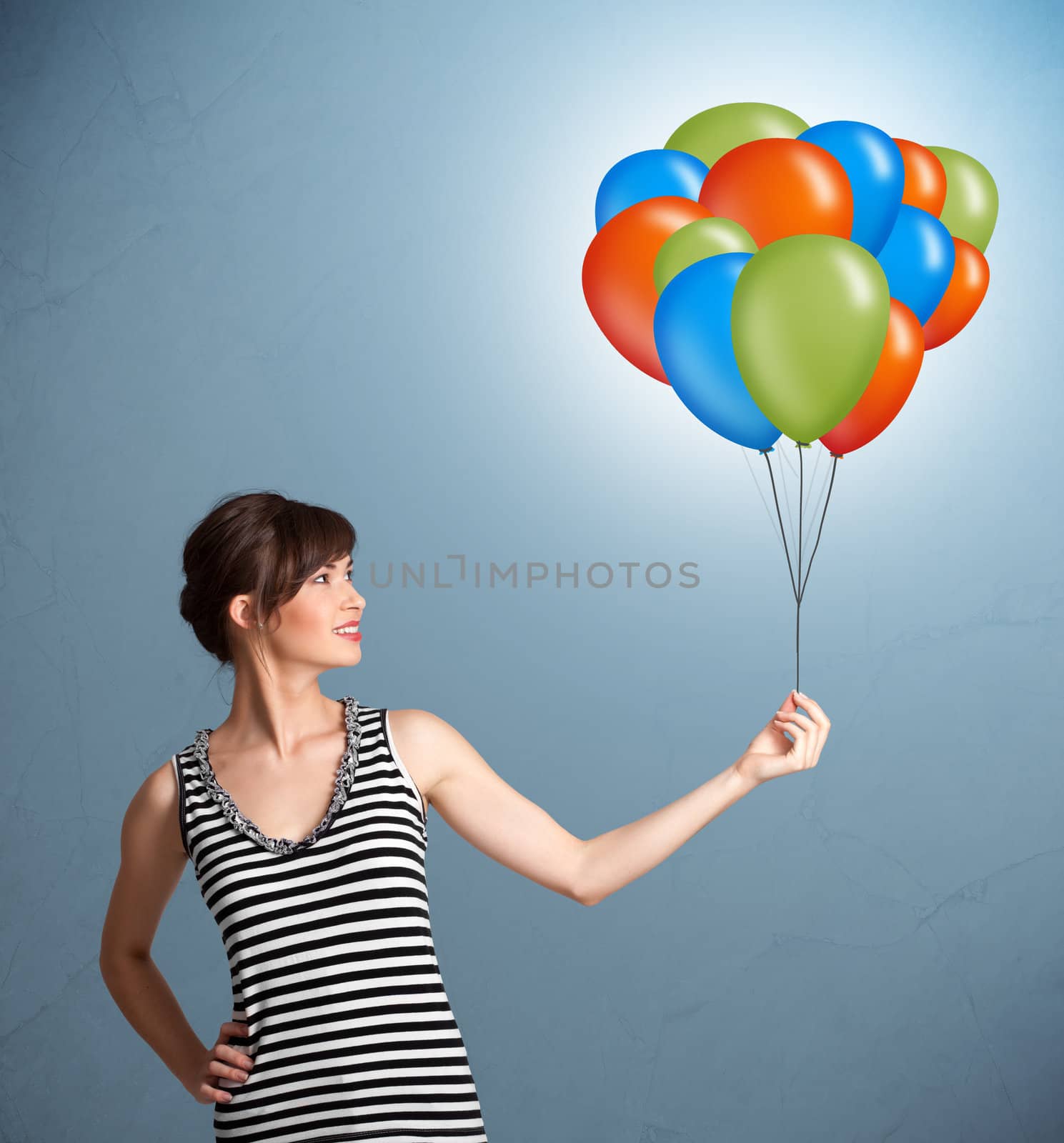 Young woman holding colorful balloons by ra2studio