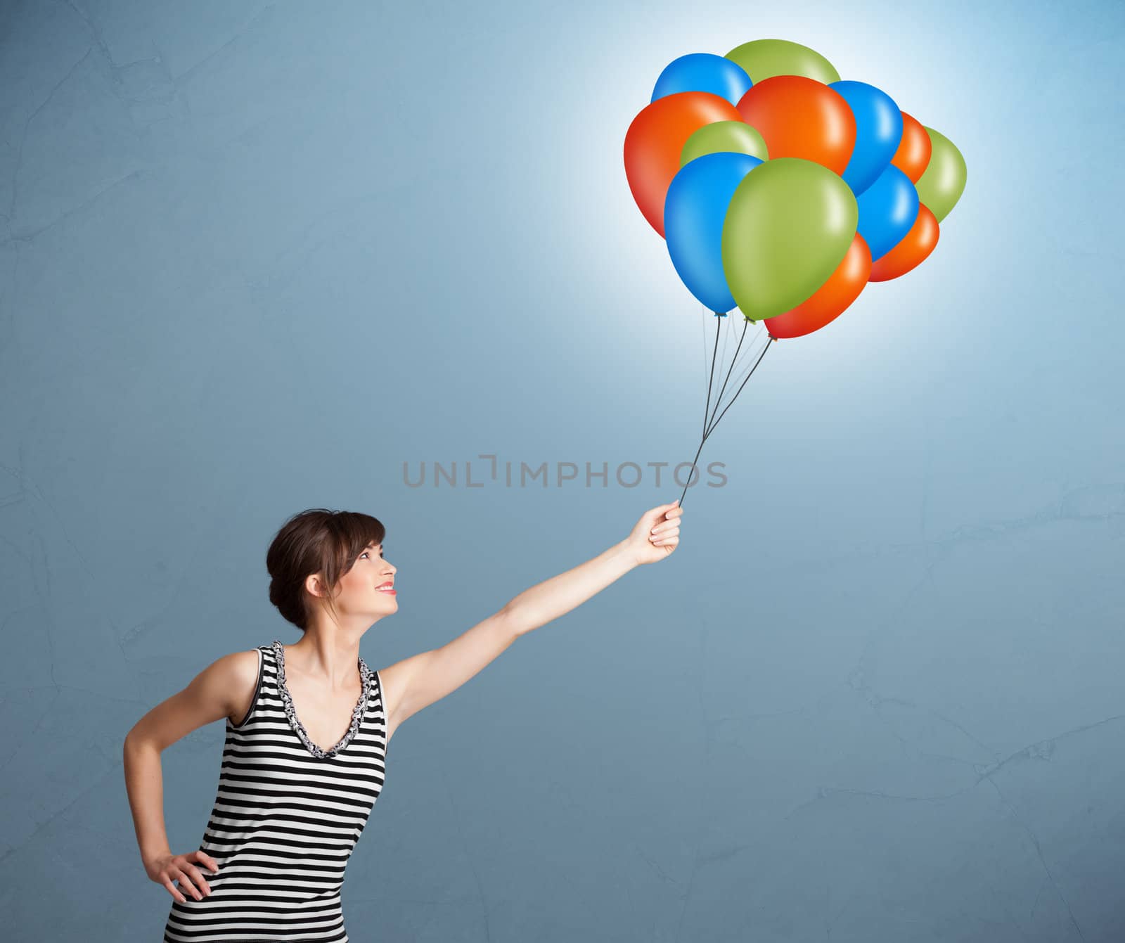 Pretty young woman holding colorful balloons