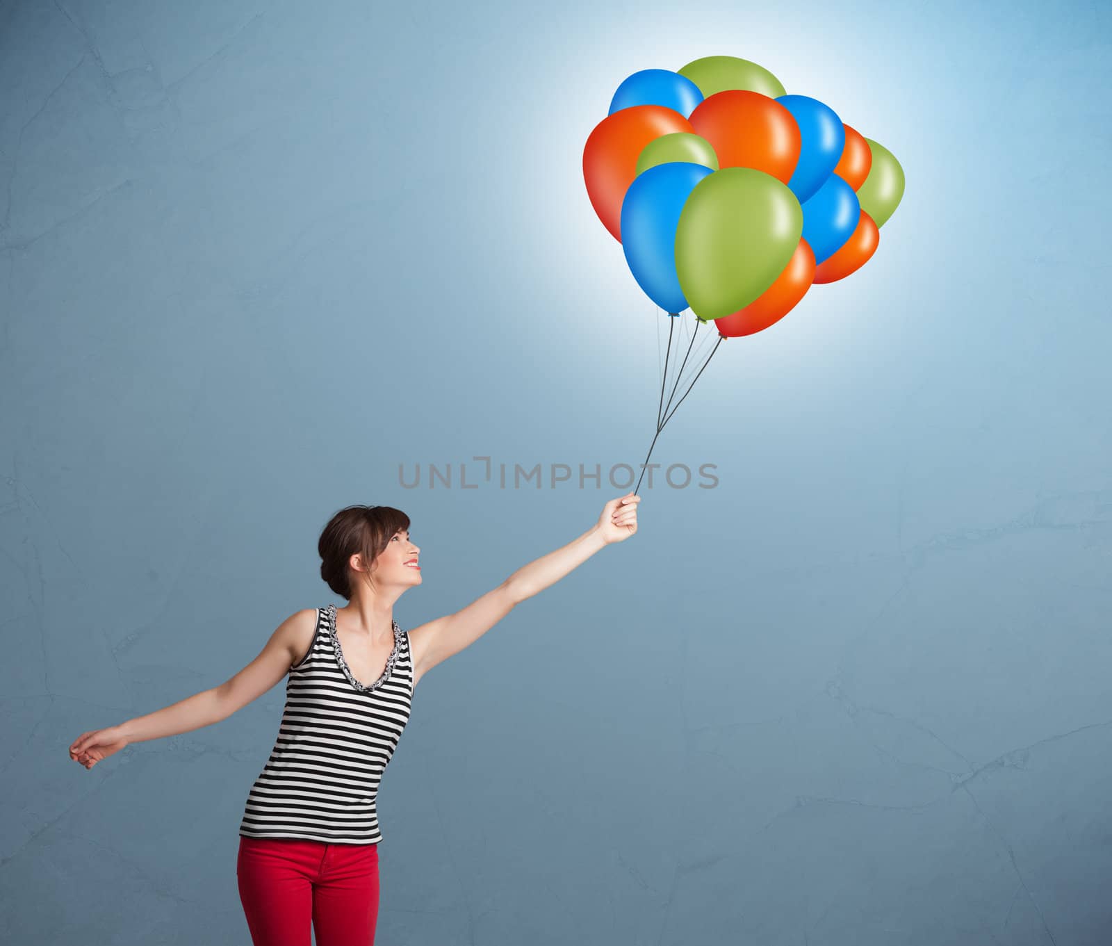 Pretty young woman holding colorful balloons