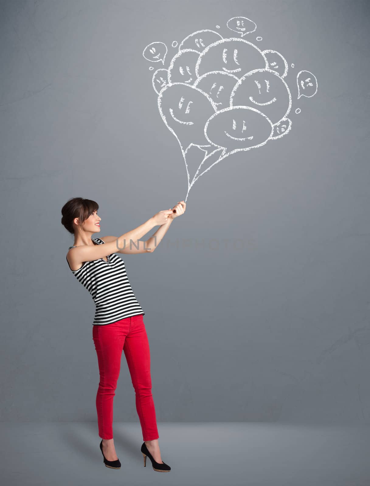 Happy young woman holding smiling balloons drawing