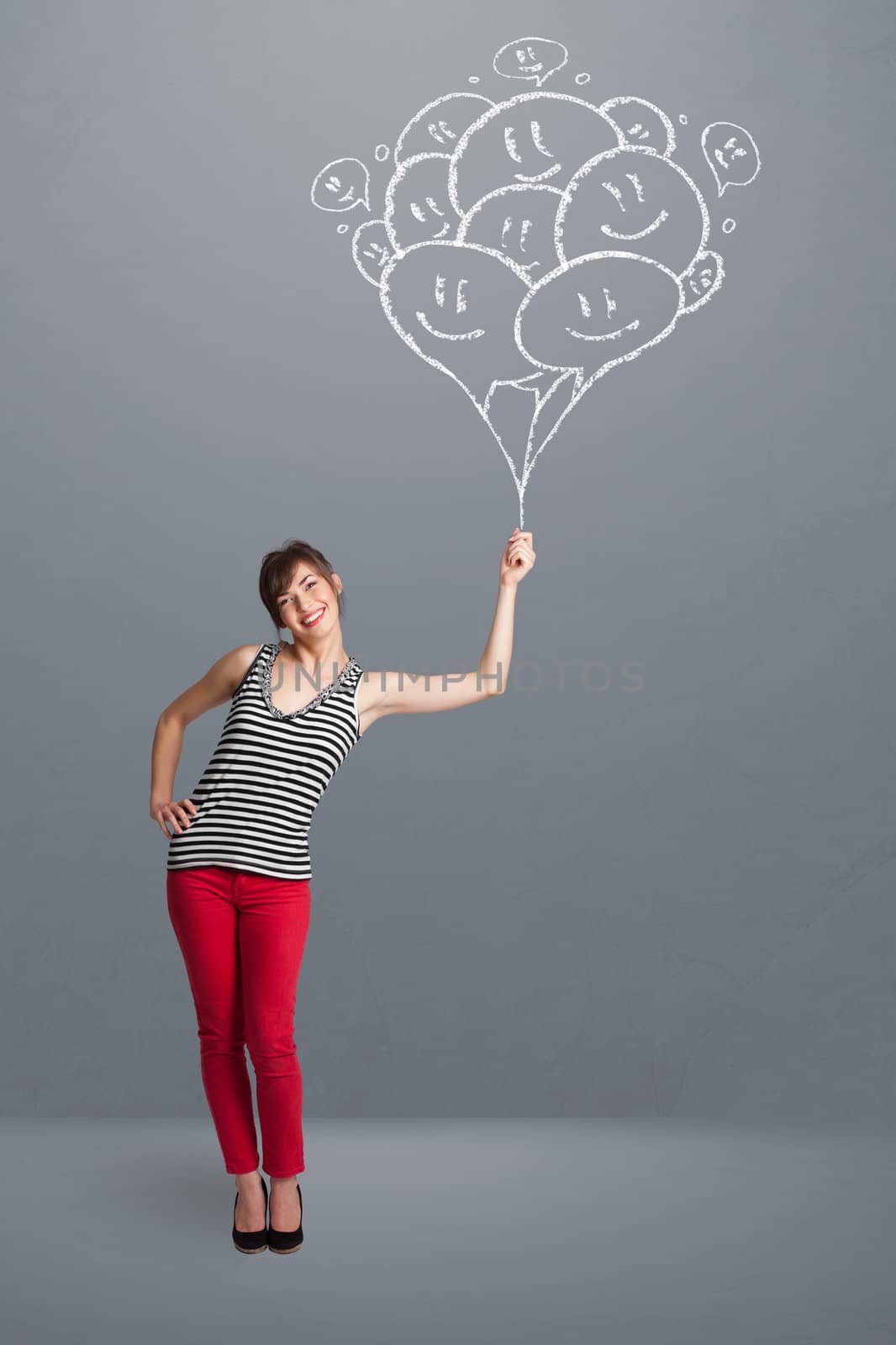 Happy young woman holding smiling balloons drawing