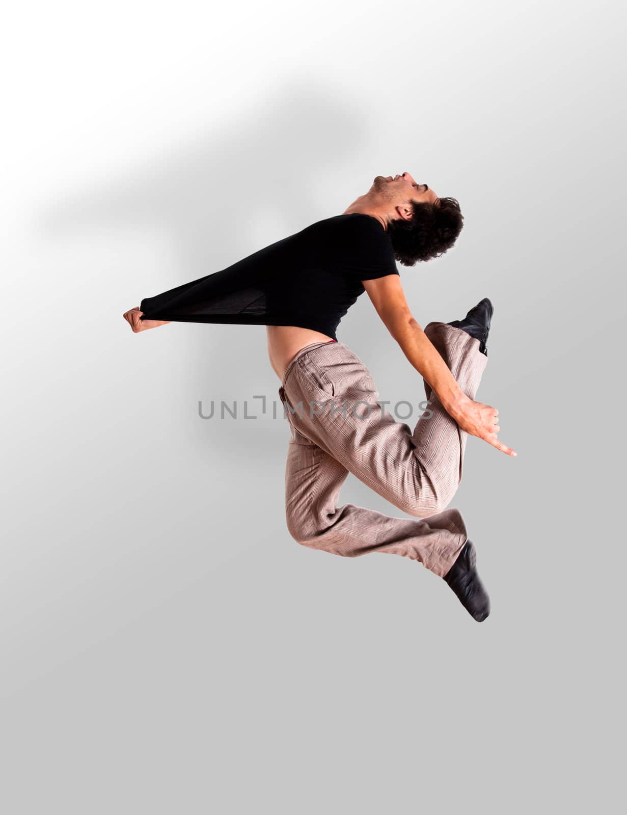stylish modern ballet dancer jumping on grey 