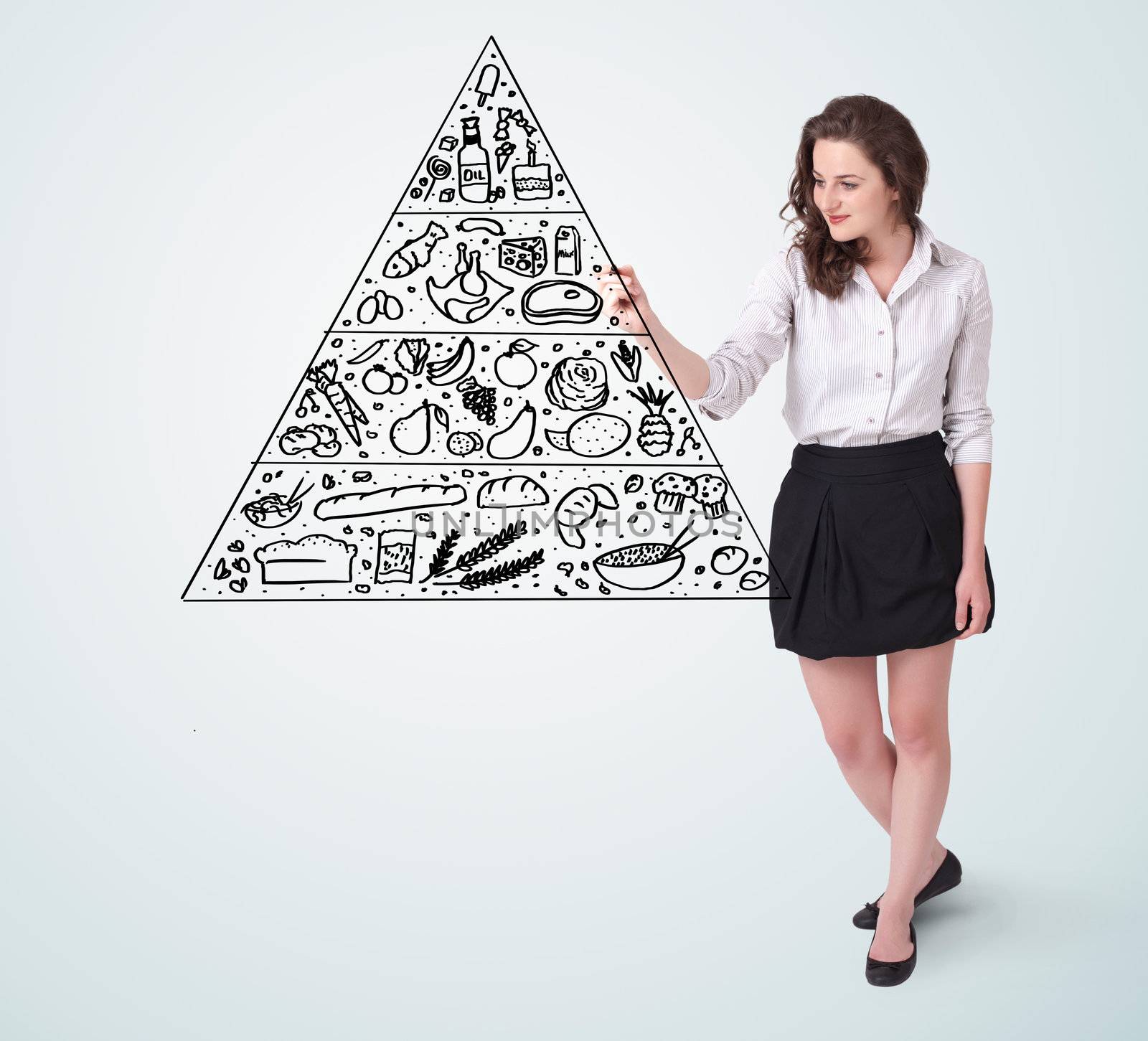 Young woman drawing a various food pyramid on whiteboard 