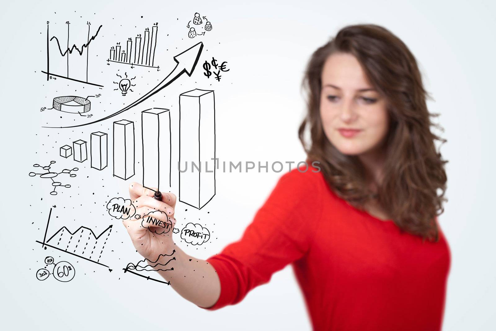 Young business woman drawing various diagrams on whiteboard