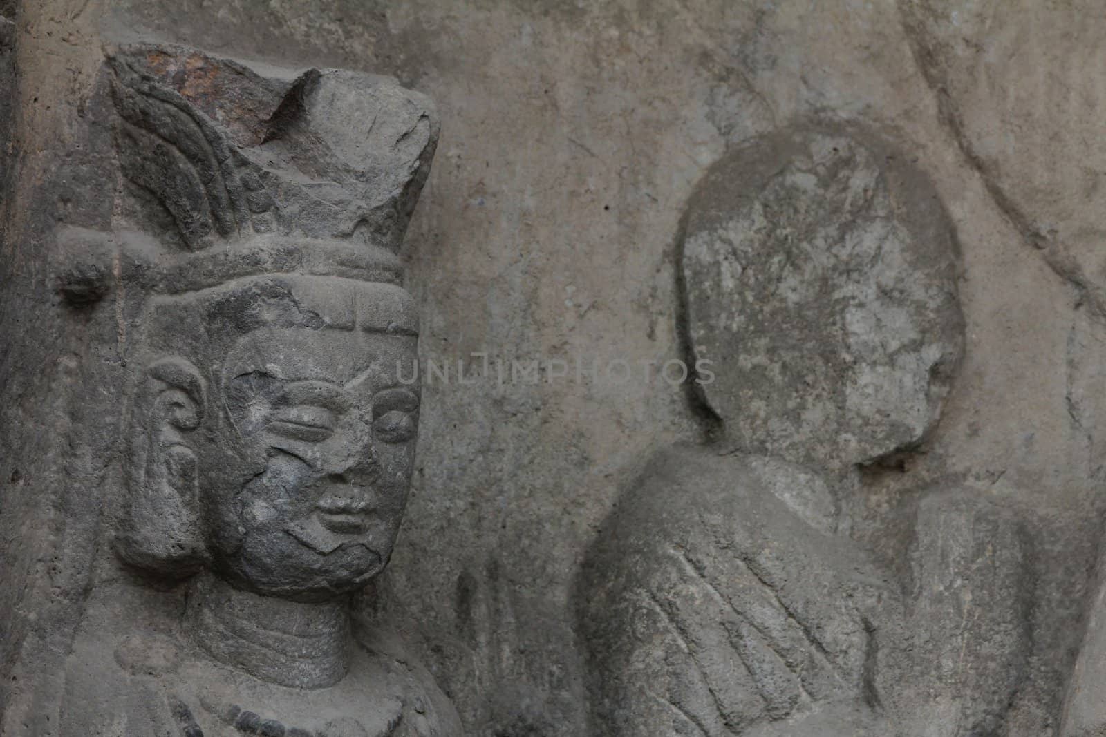 Detail of carved stone Buddha at Longmen Grottoes, a UNESCO World Heritage Site in Luoyang, China
