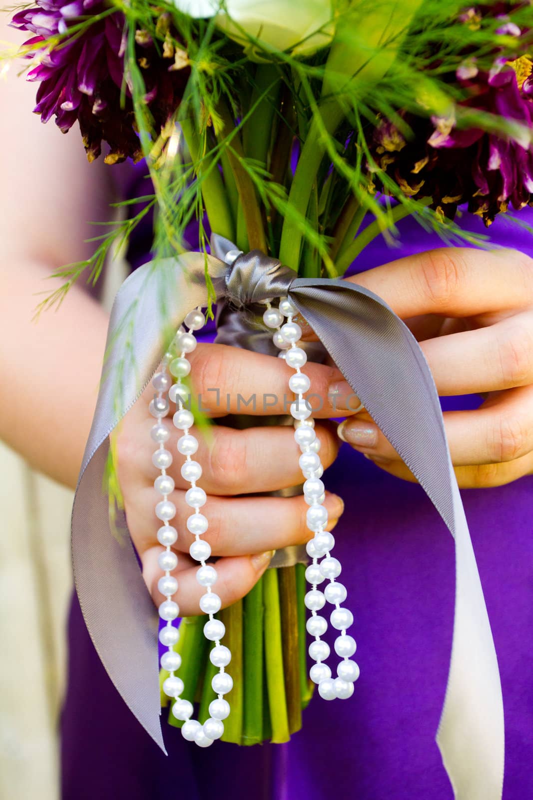 A bridesmaid holds her bouquet of beautiful flowers on a wedding day before the ceremony.