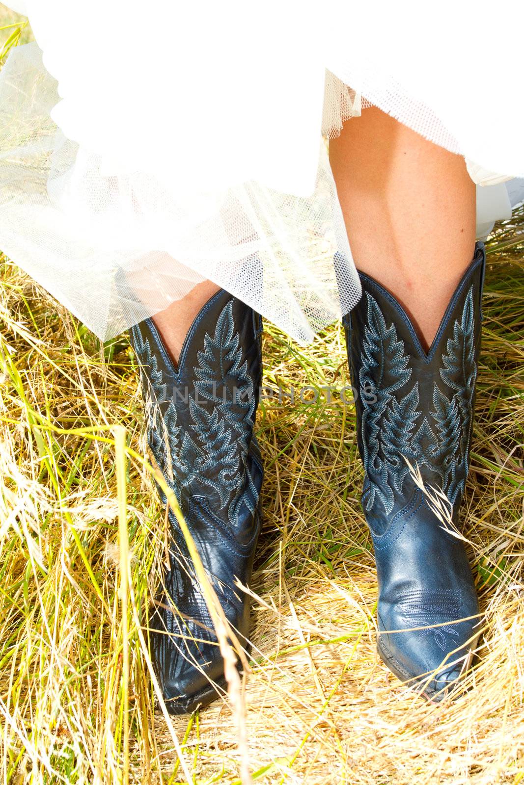 A bride wearing her black and blue cowboy (or cowgirl) boots on her wedding day.