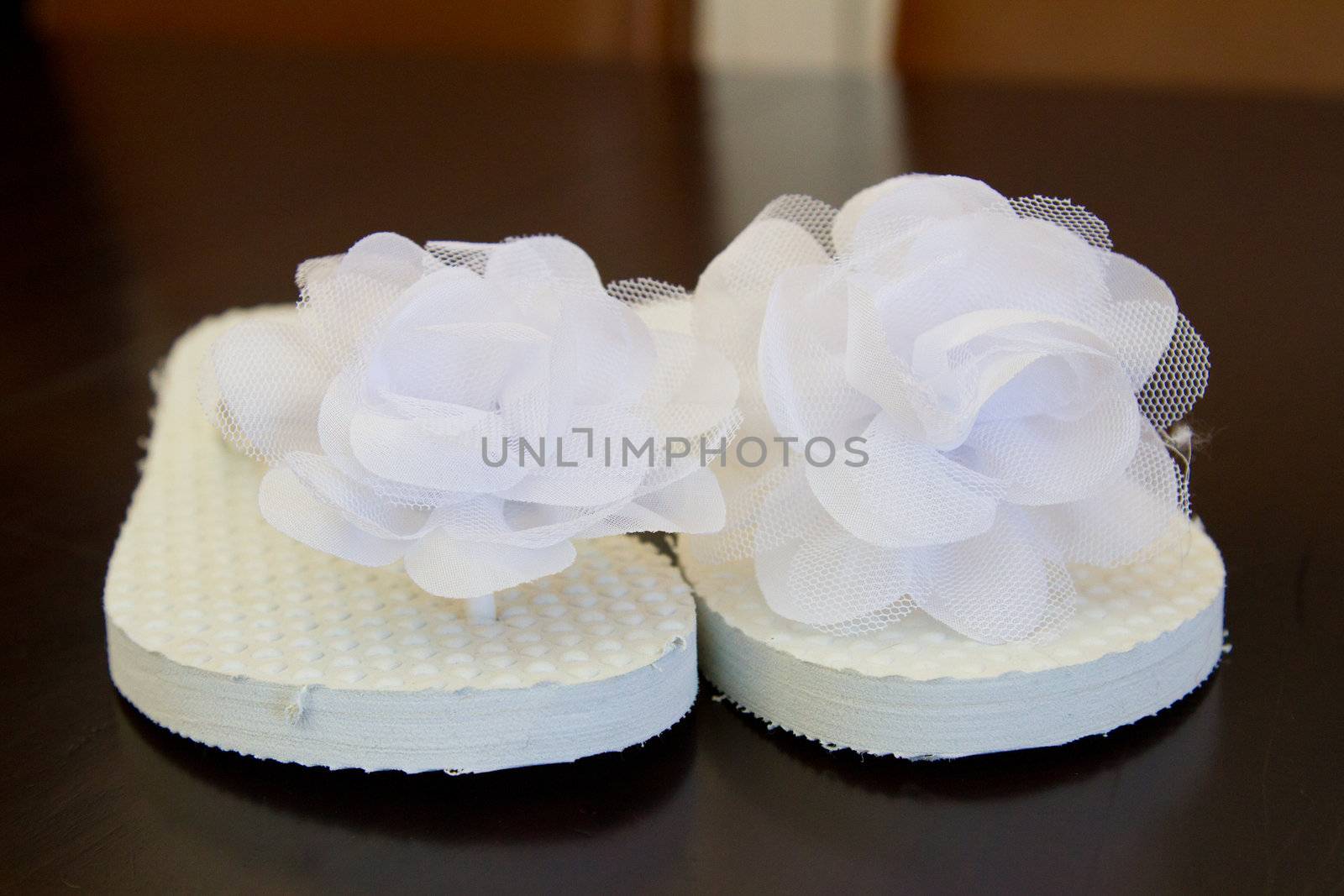 Simple white flip flop sandals for a bride to wear on her wedding day.