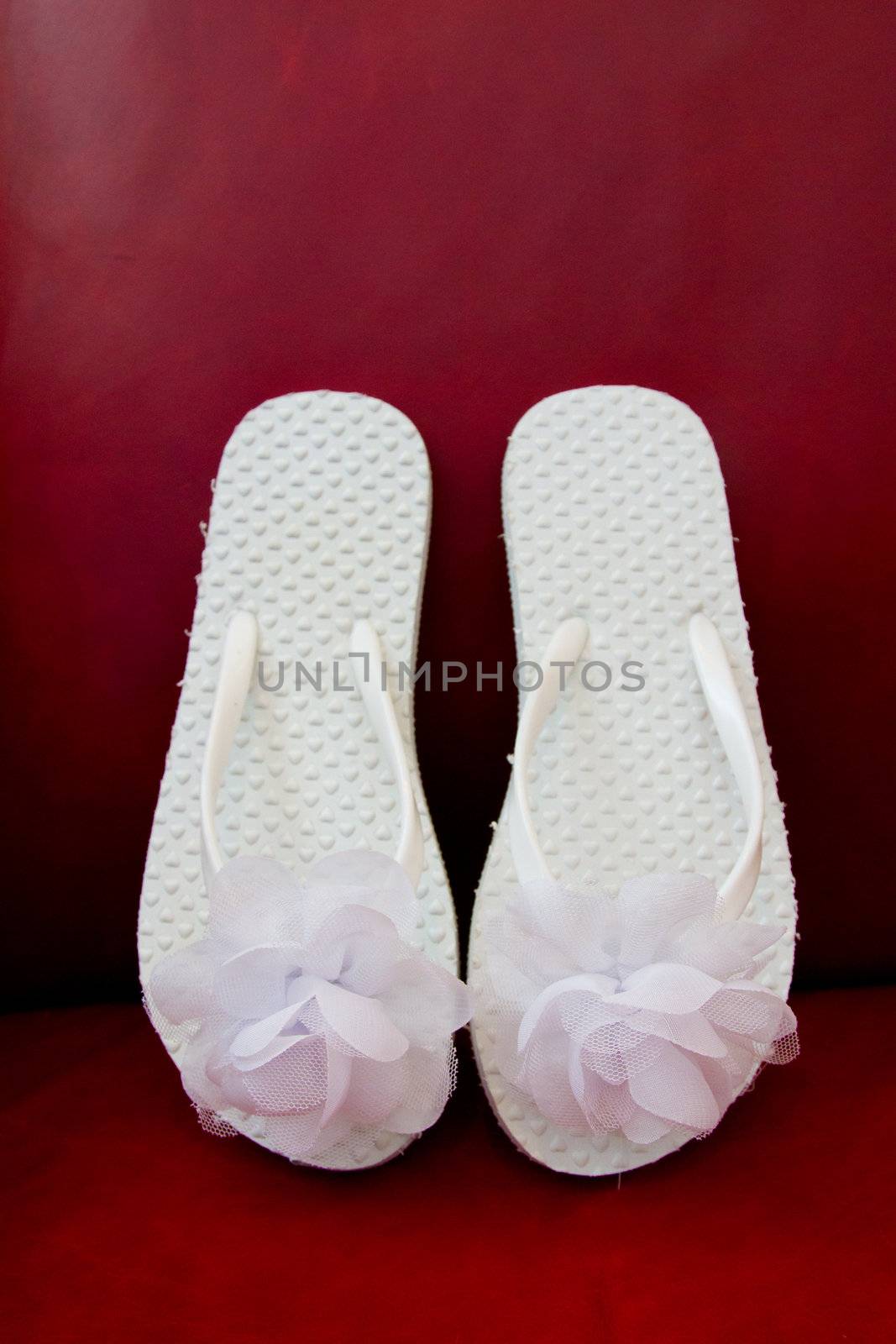 Simple white flip flop sandals for a bride to wear on her wedding day.