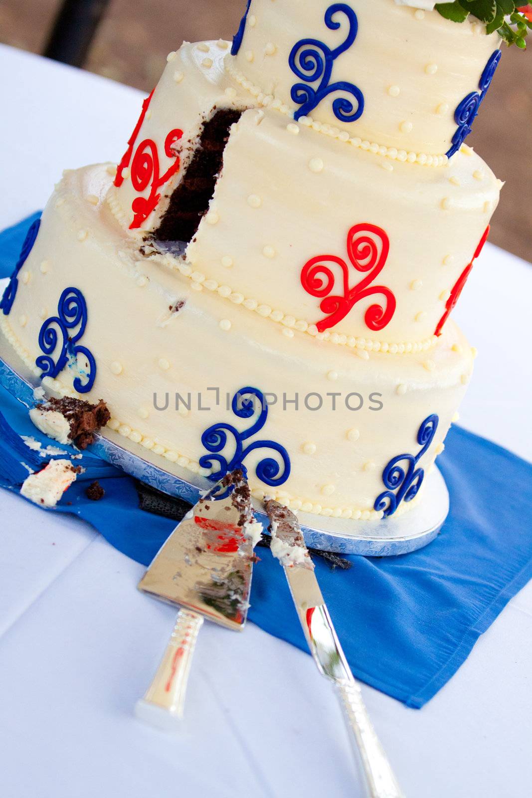 A cake with a big slice taken out by the bride and groom after they cut the cake.