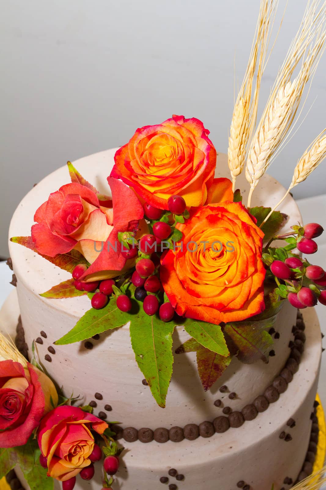 Orange flowers top this traditional white wedding cake along with wheat and harvest items.