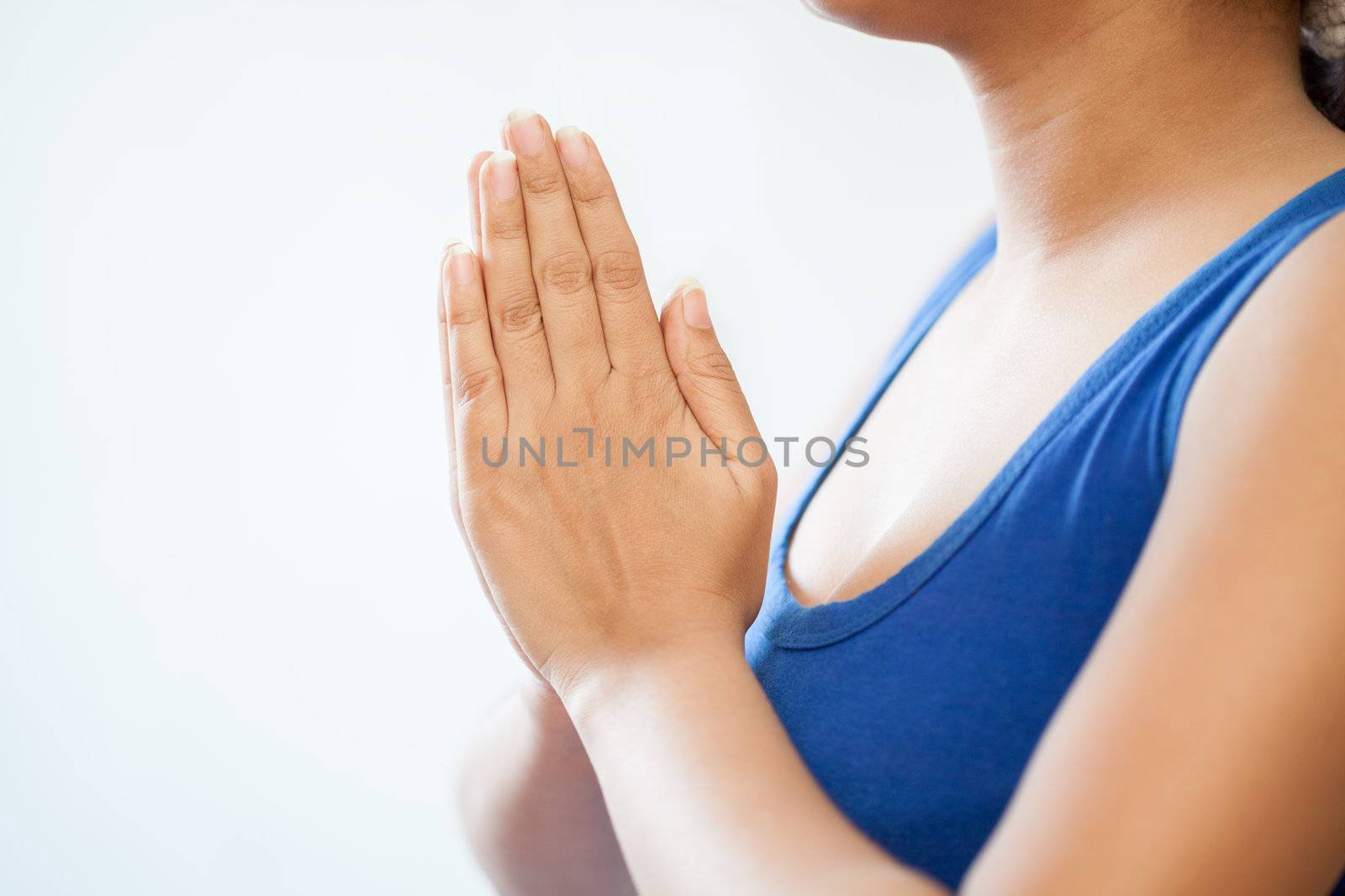 A beautiful Young Indian girl in white top doing meditation by joining hands