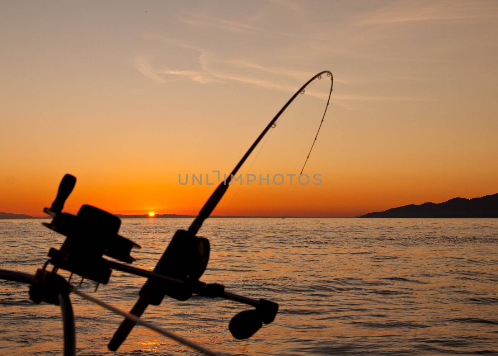 Taken just off the coast of Vancouver Island the silhouette of a down rigging fishing rod at sunset.