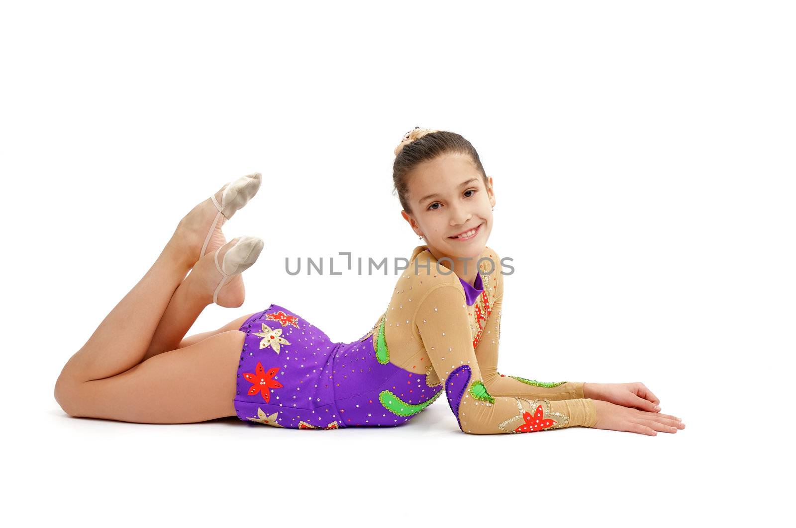 Young Girl Gymnast Relaxes after Exercising and Smiling on white background