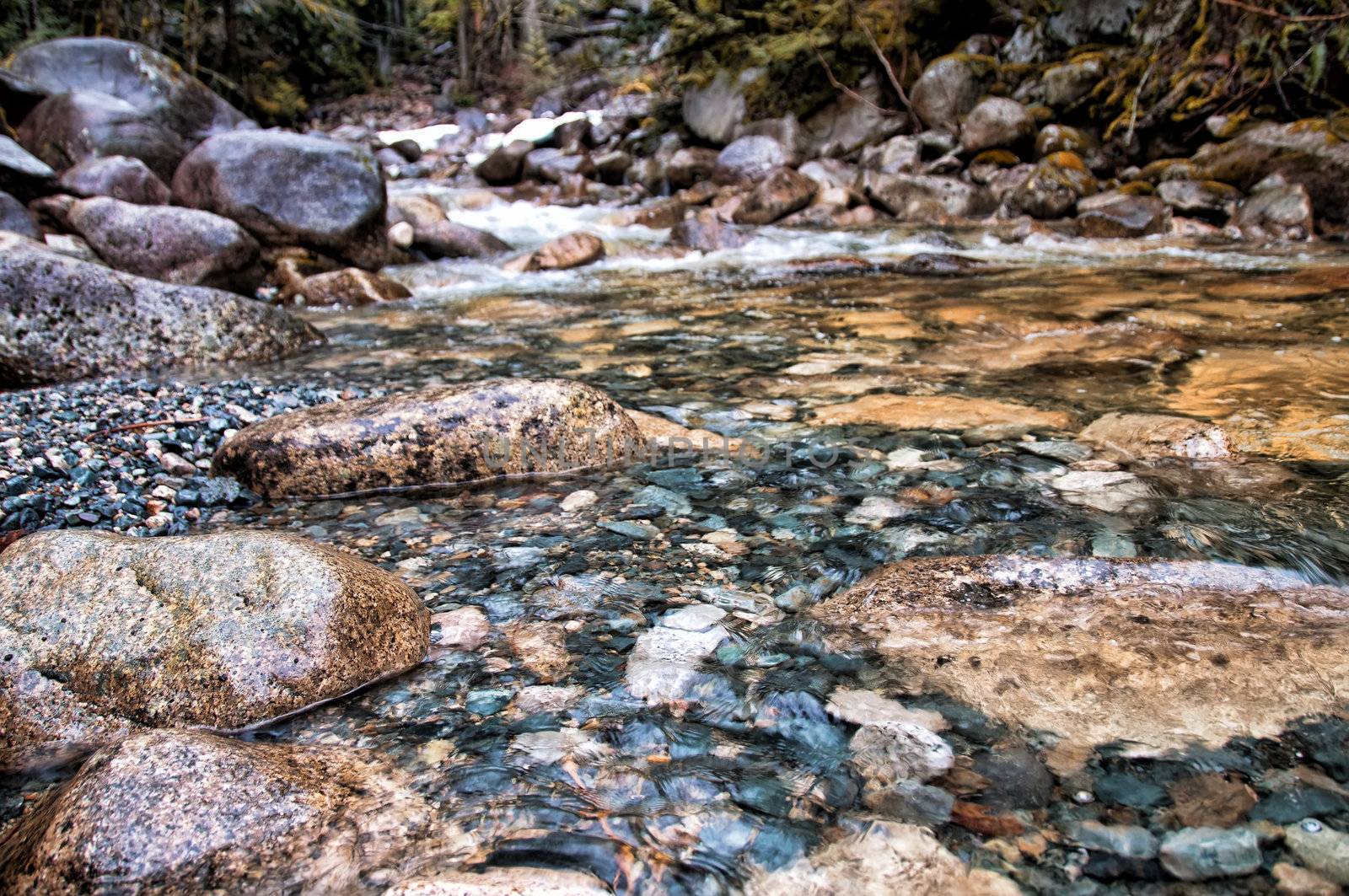 Stream with clear water and closeup of large and small rocks