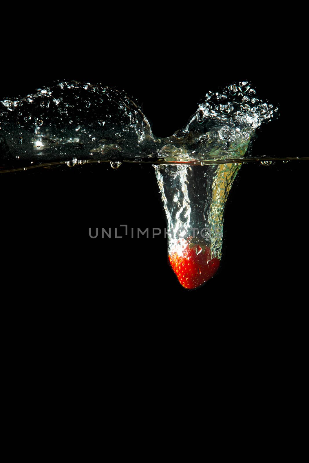 Colored red paprika in water splashes on black background