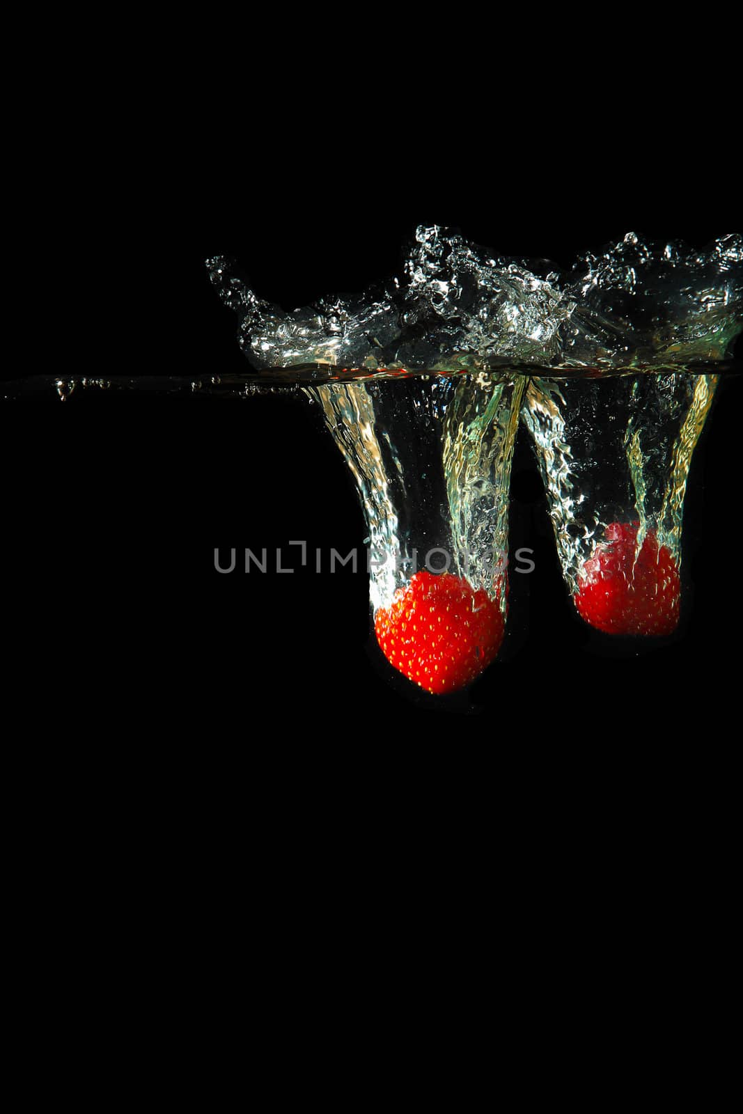 Colored red paprika in water splashes on black background