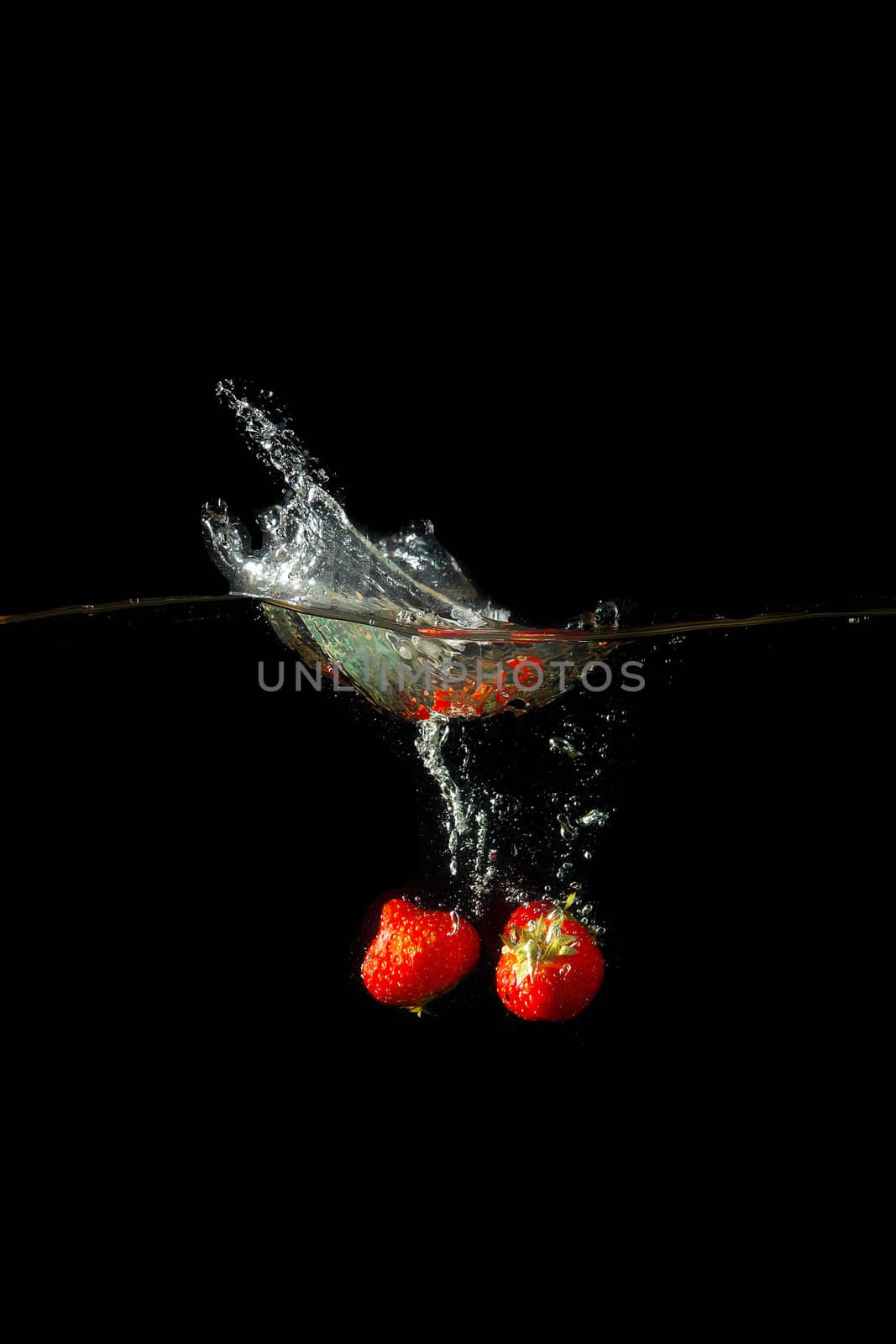 Colored red paprika in water splashes on black background