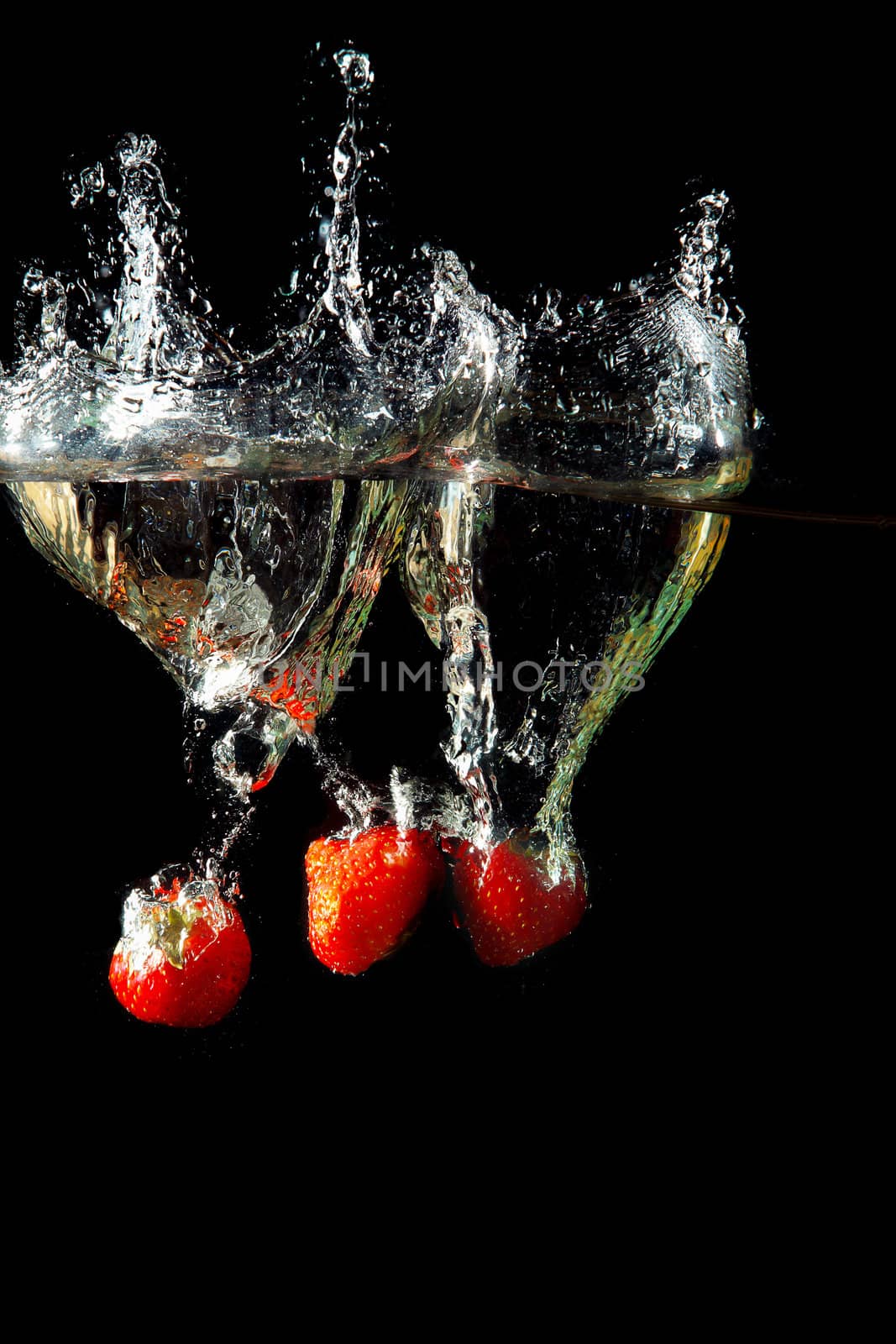 Colored red paprika in water splashes on black background