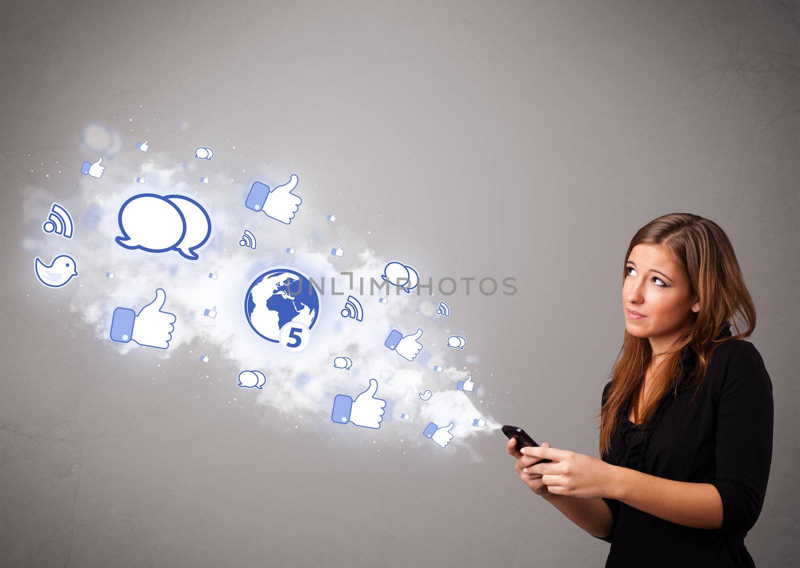 Pretty young girl holding a phone with social media icons in abstract cloud