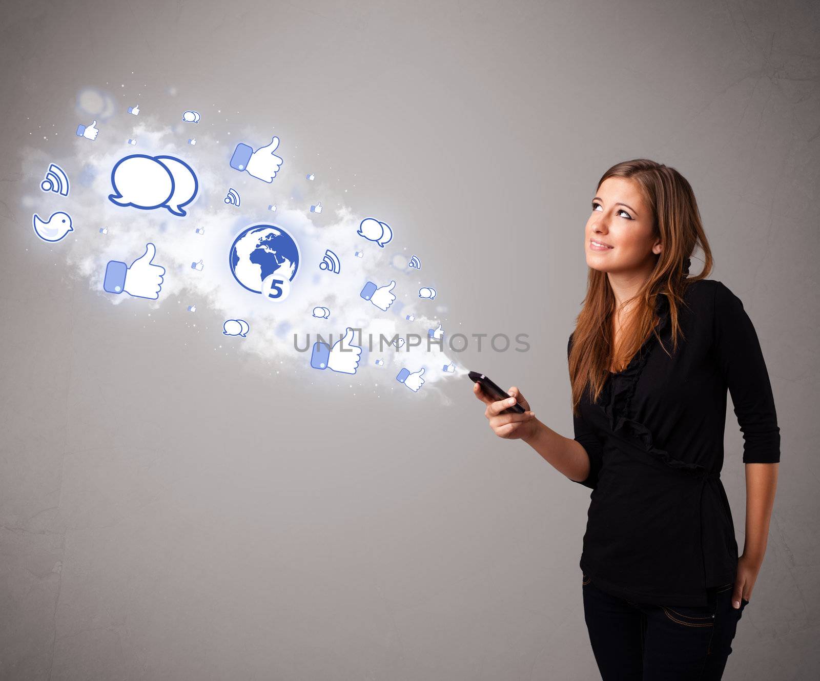 Pretty young girl holding a phone with social media icons in abstract cloud