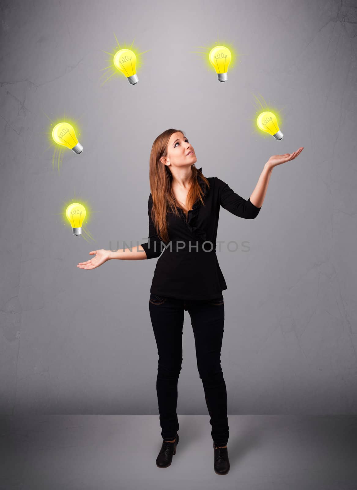 beautiful young lady standing and juggling with light bulbs